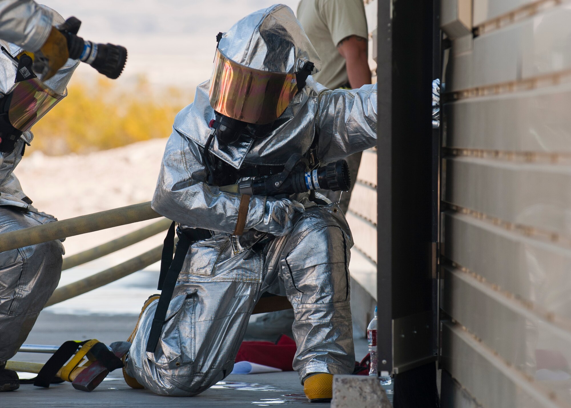 Maj. Gen. Jay Silveria, U.S. Air Force Warfare Center commander, prepares to enter the structural trainer with 99th Civil Engineer Squadron firefighters to subdue a fire during a training exercise April 17, 2014, at Nellis Air Force Base, Nev. By participating in the firefighting exercises, Silveria was able to experience first-hand how the 99th CES firefighters maintain their edge. (U.S. Air Force photo by Airman 1st Class Thomas Spangler)