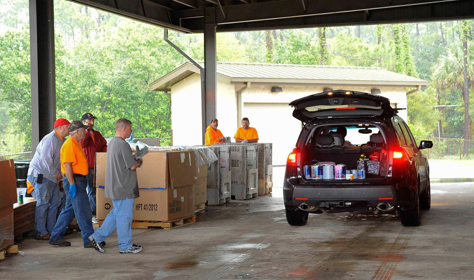 Volunteers prepare to collect paint cans from a car during Household Hazardous Waste Collection Day at Hurlburt Field, Fla., April 18, 2014. Paint products were one of the many items collected and disposed of during the event. (U.S. Air Force photo/Airman 1st Class Andrea Posey)