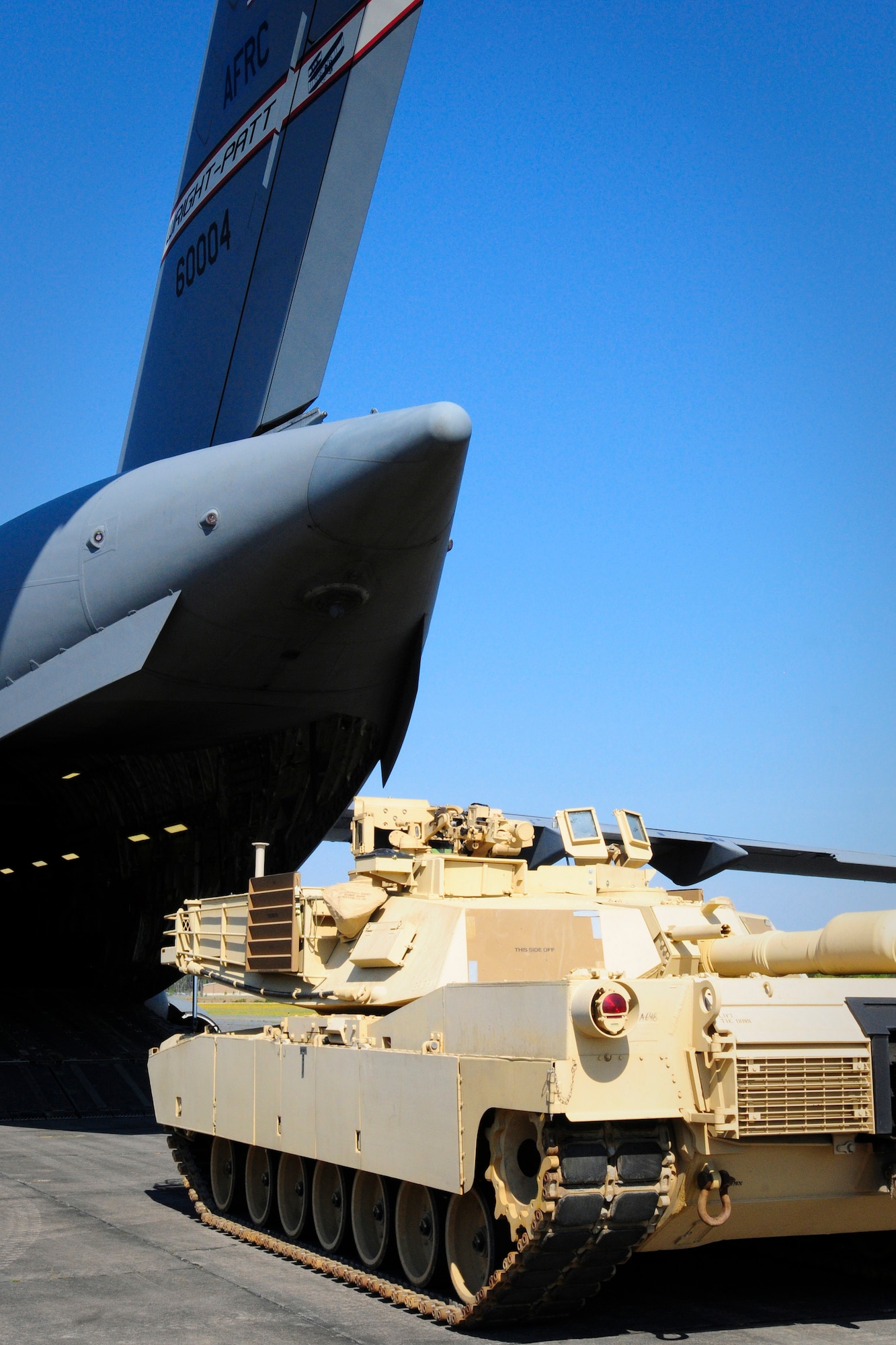 A 445th Airlift Wing C-17 Globemaster III sits in the background in preparation for the onload of the M1A1SA Abrams Main Battle Tank April 11 at Wright Army Airfield, Ga. (Photo by Sgt. Brian Calhoun/Released)