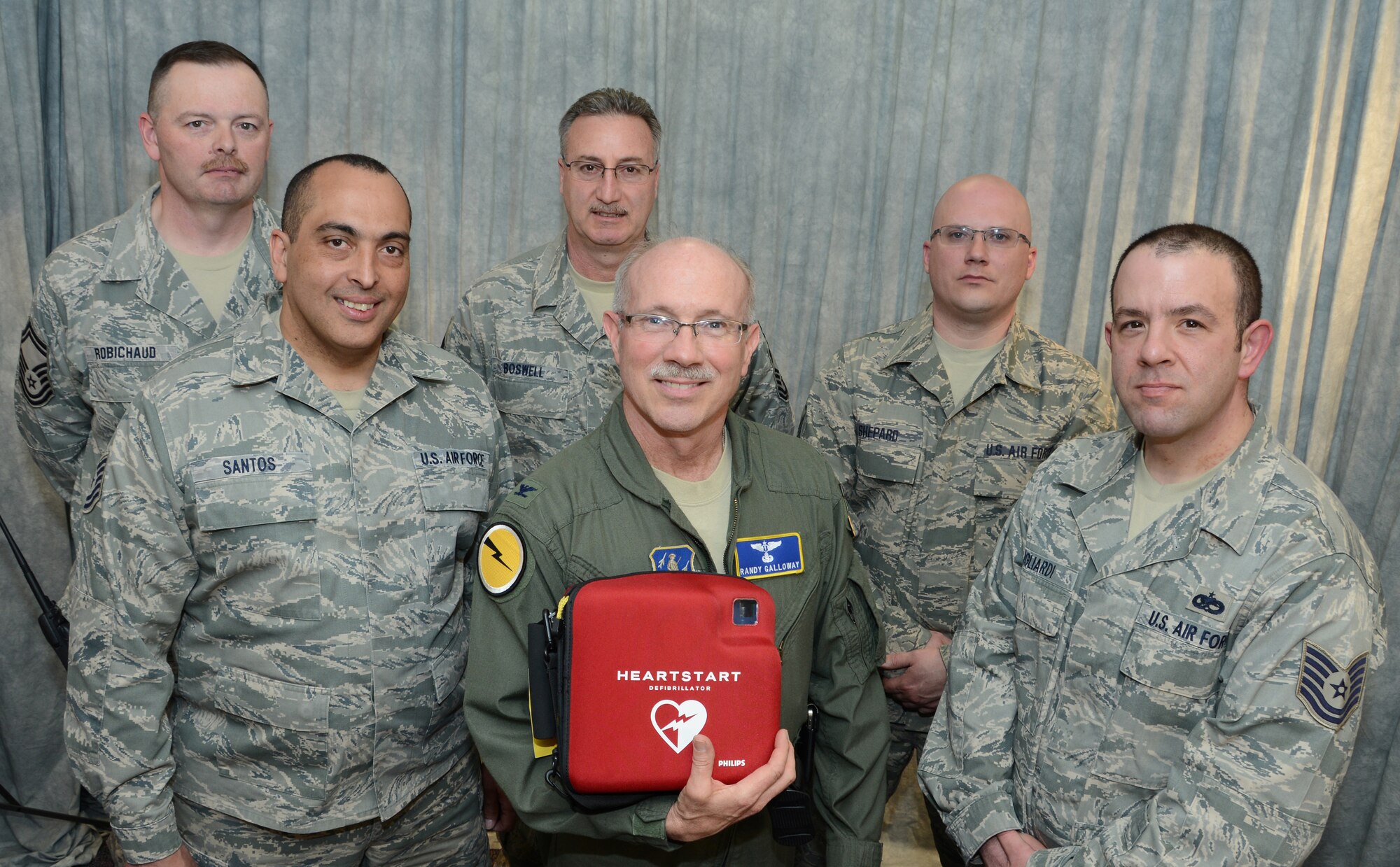 Senior Master Sgt. Curt Robichaud, avionics section supervisor with the 103rd Maintenance Squadron, Chief Master Sgt. Greg Boswell, the component maintenance chief with the 103rd Maintenance Squadron, Master Sgt. Jonathan Shepard, aircraft fuel systems specialist with the 103rd Maintenance Squadron, Tech. Sgt. Angel Santos, machine shop supervisor with the 103rd Maintenance Squadron, Col. James Galloway, commander of the 103rd Medical Group and Tech. Sgt. Anthony Gagliardi Jr., a budget analyst with the 103rd Maintenance Group proudly display an automated external defibrillator at Bradley Air National Guard Base, East Granby, Conn., April 6, 2014.  The team is credited with saving the life of Chief Master Sgt. Kevin Salsbury, a labor relations specialist with the Connecticut National Guard, using an AED like the one show just two days earlier here.  (U.S. Air National Guard photo by Master Sgt. Erin McNamara) 
