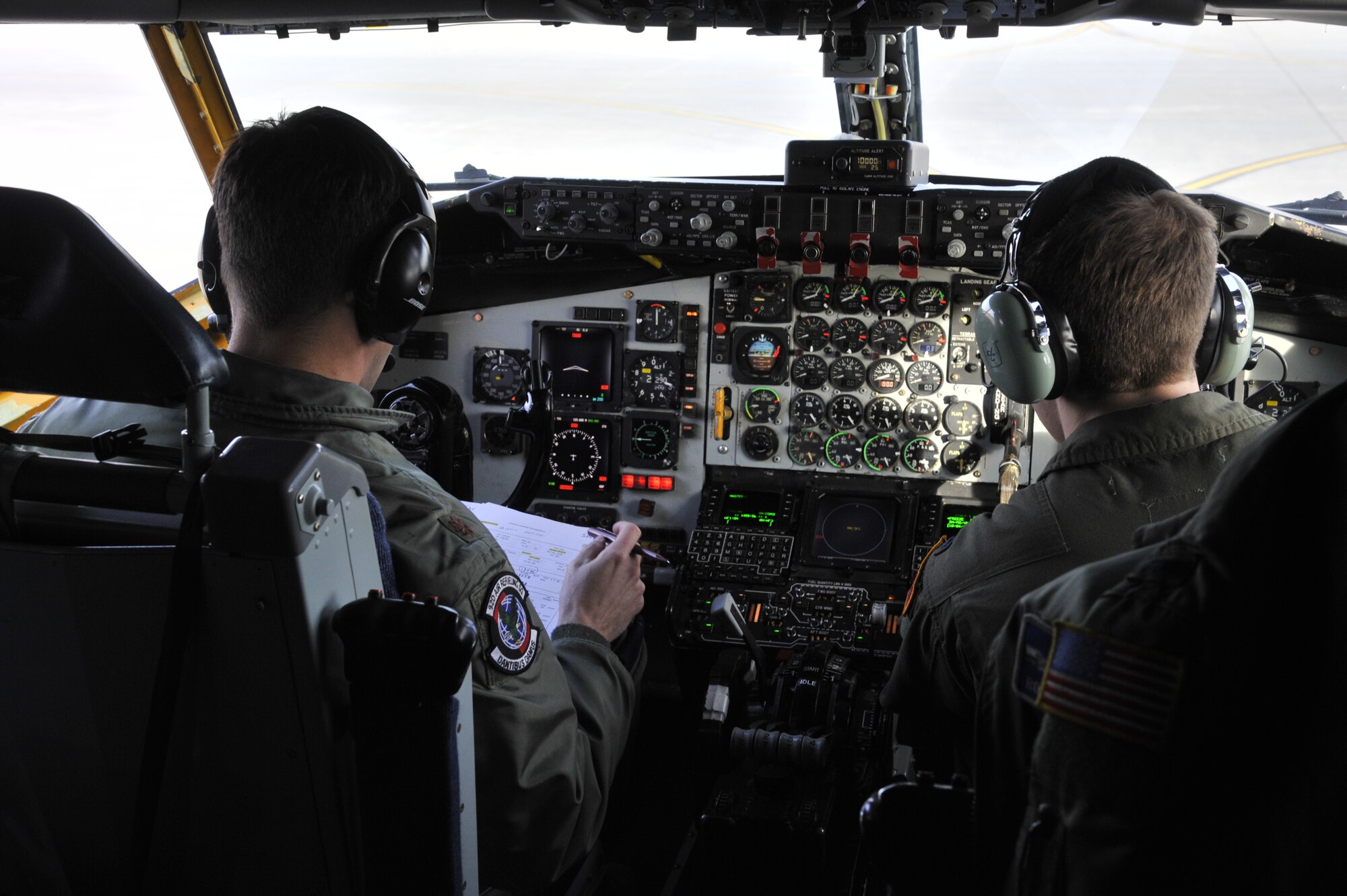 Maj. Denique Asion and 1st Lt.Ross Ostarello, 92nd Air Refueling Squadron KC-135 Stratotanker pilots, preform pre-flight checks at Fairchild Air Force Base, Wash., April 10, 2014. Pre-flight checks are performed with ground crew members to ensure the aircraft is mission ready. (U.S. Air Force photo by Senior Airman Mary O'Dell/Released)