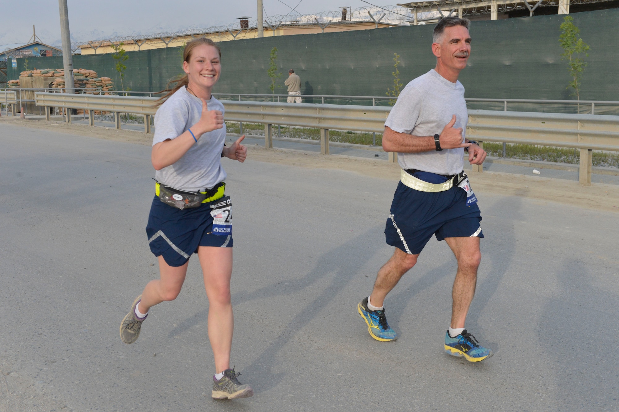 U.S. Air Force 1st Lt. Rachael Bryson and Chief Master Sgt. John Brinkley run together during the Boston Marathon Shadow Run-Afghanistan 2014 at Bagram Airfield, Afghanistan, April 18, 2014. Over 600 runners participated in the race.(U.S. Air Force photo by Senior Master Sgt. Gary J. Rihn/Released)