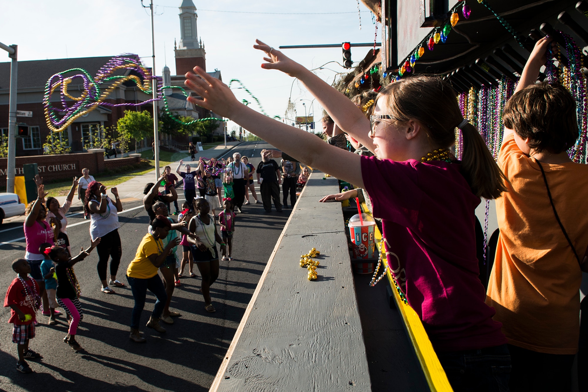 People along the Holiday in Dixie parade route scramble for Mardi Gras beads as they're thrown from the "Salute to Military" float, April 12, 2012, Shreveport, La. Airmen assigned to the 307th Bomb Wing and their family members manned the float which took them down the streets of downtown Shreveport. (U.S. Air Force photo by Master Sgt. Greg Steele/Released)