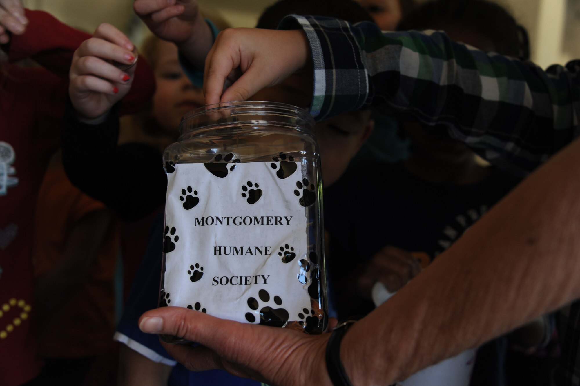 Children from the Maxwell Child Development Center donate money to the Montgomery Humane Society April 16, 2014. They donated money in conjunction with a visit from three MHS shelter dogs. The visit was coordinated in celebration of Month of the Military Child. (U.S. Air Force photo by Staff Sgt. Natasha Stannard)