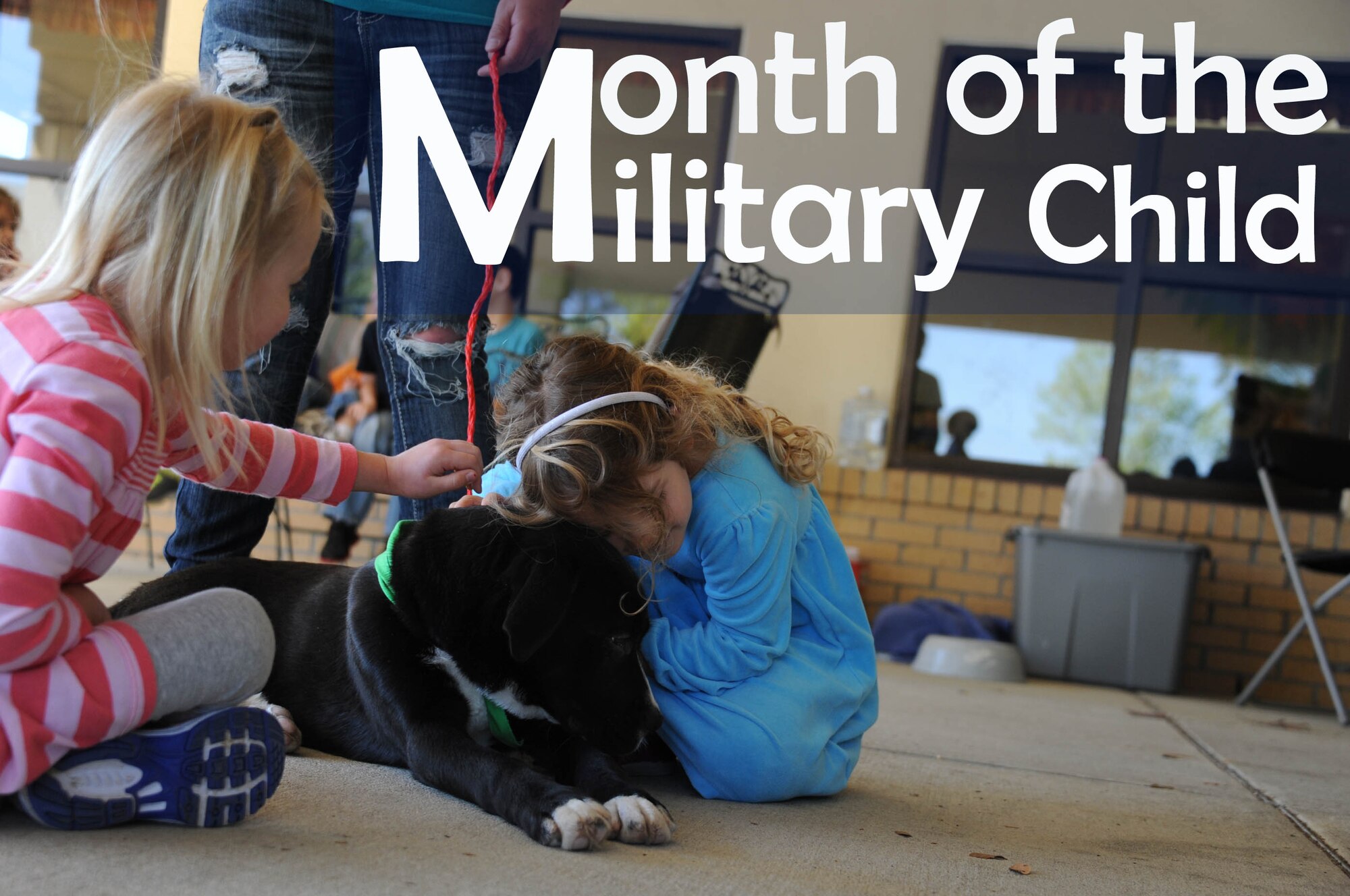 Smoke embraces hugs from children at the Maxwell Child Development Center April 16, 2014. Three adoptable dogs visited the center in celebration of Month of the Military Child. (U.S. Air Force photo illustration by Staff Sgt. Natasha Stannard)
