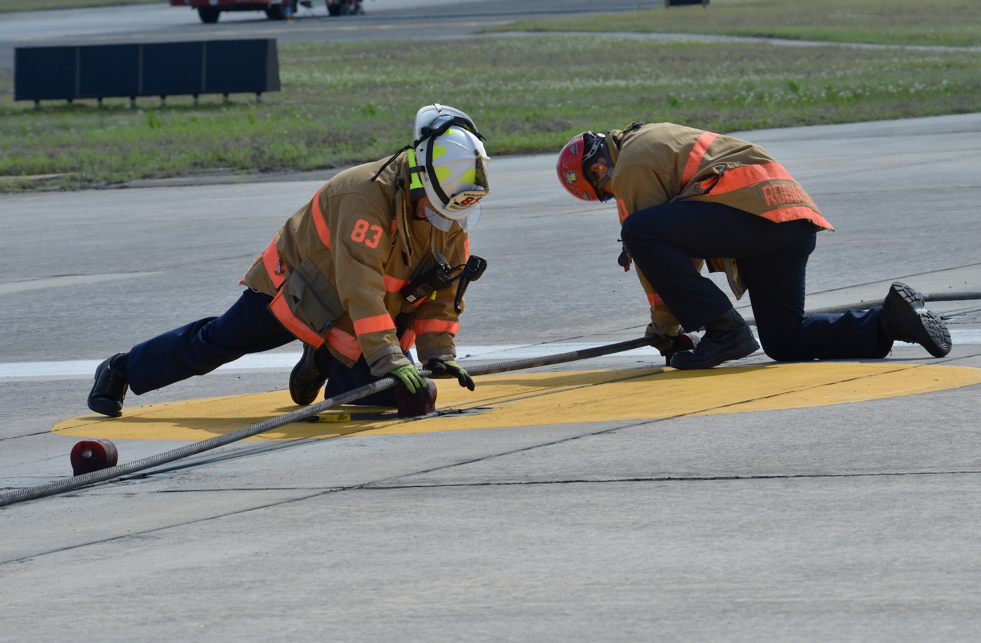 Base firefighters prepare the cable system prior to the F-15 landing at Robins. The use of the system was for a scheduled annual certification engagement, April 8, 2014.(U..S. Air Force photo by Ed Aspera) 
