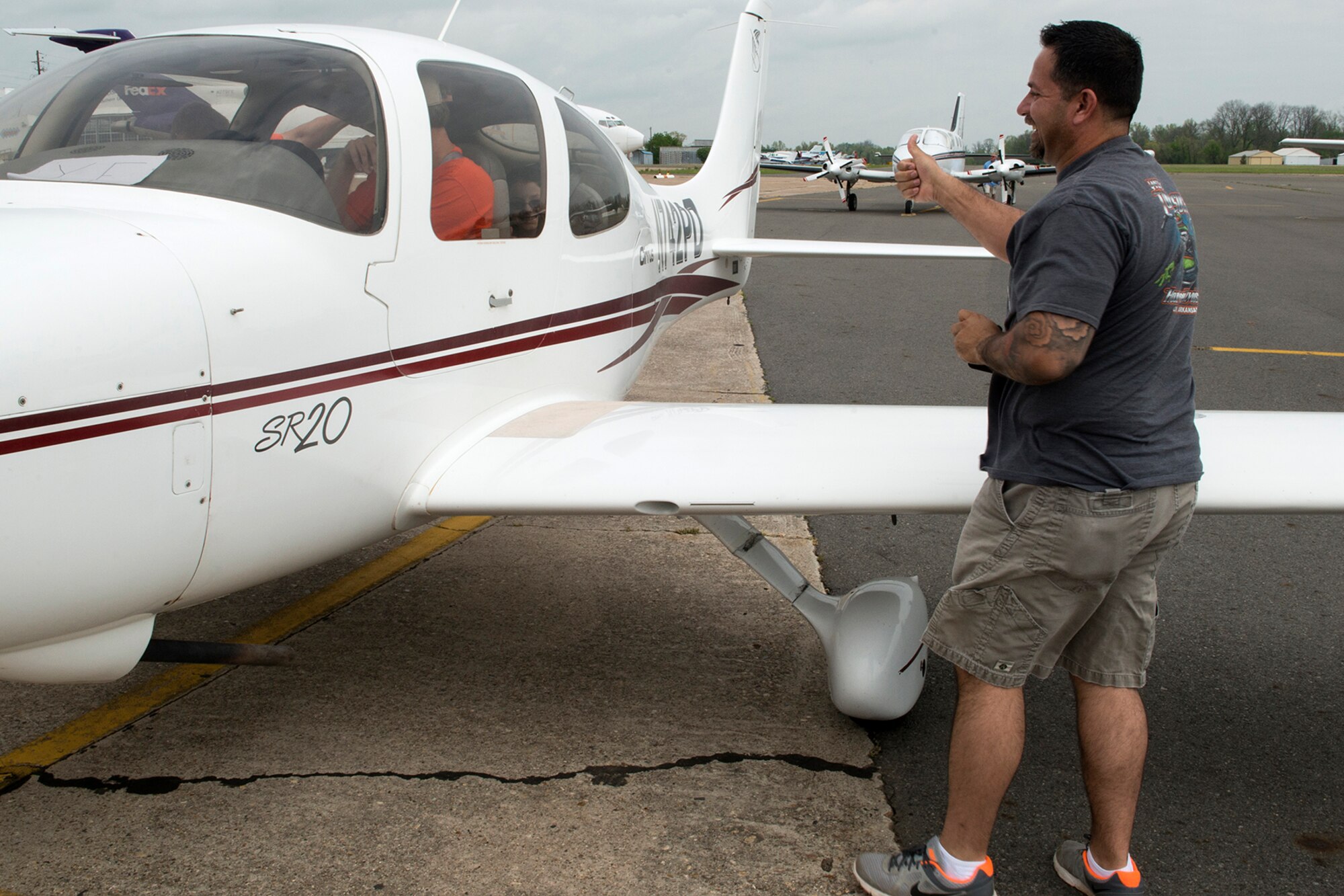 Randy Long gives a thumbs up to his daughters before their first flight in an airplane at Shreveport Downtown Airport, April 12, 2014, Shreveport, La. The 343rd Experimental Aircraft Association, with the support of a group of volunteer pilots and their aircraft, offered free rides to kids ages 8-18 to introduce them to the world of aviation. (U.S. Air Force photo by Master Sgt. Greg Steele/Released)