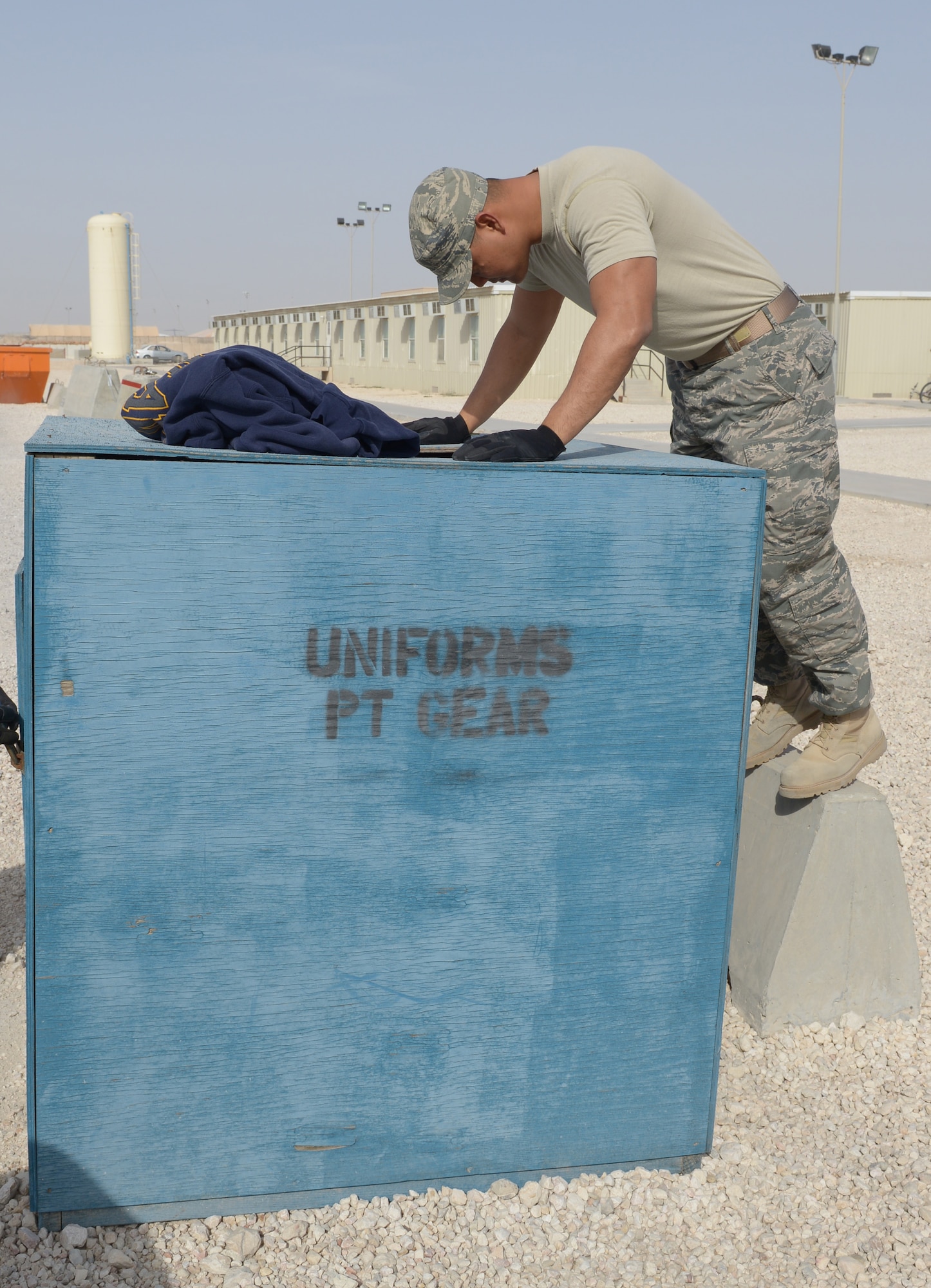 Staff Sgt. Vianney Hocog looks into a uniform drop off box at Al Udeid Air Base, Qatar, Apr. 15, 2014. The 379th Air Expeditionary Wing Force Protection shop collects and shreds unserviceable military uniforms weekly to prevent operation security violations and ensure adversaries do not have an opportunity to impersonate U.S. military members for an attack. Hocog the 379th AEW Force Protection NCO in charge, deployed from Tyndall Air Force Base, Fla., and a Rota, Mariana Islands, native. (U.S. Air Force photo/Senior Airman Hannah Landeros)