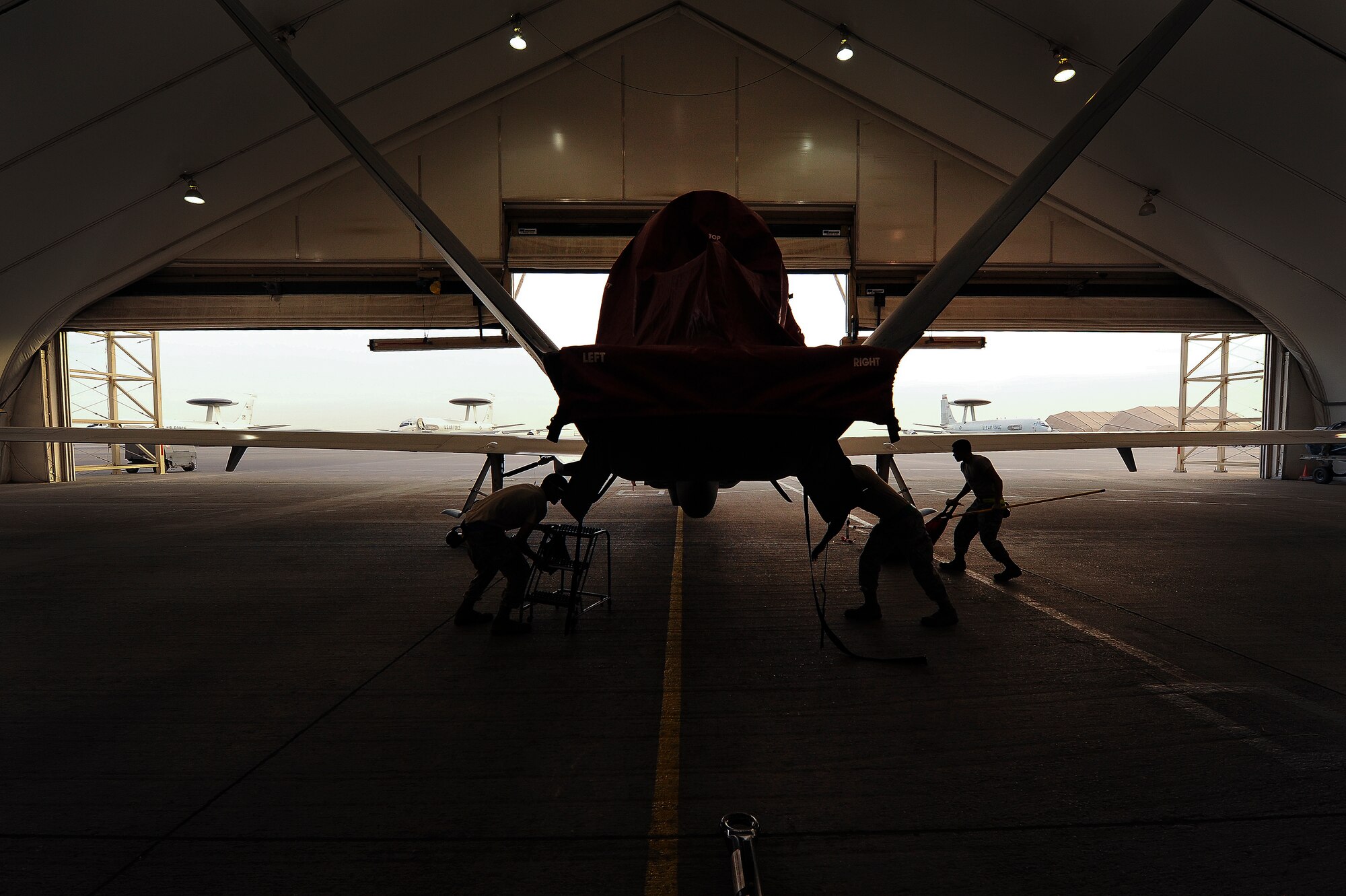 Airmen from the 380th Expeditionary Aircraft Maintenance Squadron prepare an RQ-4 Global Hawk for a flight April 15, 2014, at an undisclosed location in Southwest Asia. The Global Hawk is an unmanned aircraft that provides intelligence, surveillance, reconnaissance and communications capabilities over Southwest Asia. (U.S. Air Force photo by Tech. Sgt. Russ Scalf/Released)
