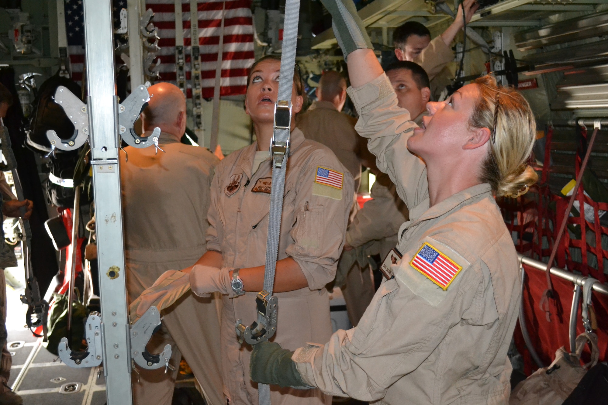 Staff Sgt. Molly Farrand and Senior Airman Deonda De Leon, medical technicians with the 379th Expeditionary Aeromedical Evacuation Squadron, discuss the best configuration for the six litters as they load them on the C-130 Hercules prior to an AE mission in support of Operation Enduring Freedom, April 16, 2014, Al Udeid Air Base, Qatar.  A crew of two nurses and three medical technicians work as a choreographed team as they configure, load, and inspect all emergency equipment litters and medical supplies on the aircraft to ensure function and preparation for any and all types of medical emergencies, as well as safety for all crew and patient on board.  Farrand is deployed from the Wyoming Air National Guard and a Fort Collins, Colo. native.  De Leon is deployed from Ramstein Air Base, Germany and a native of Vanceburg, Ky.  (U.S. Air Force photo by Maj. Nicole David) 