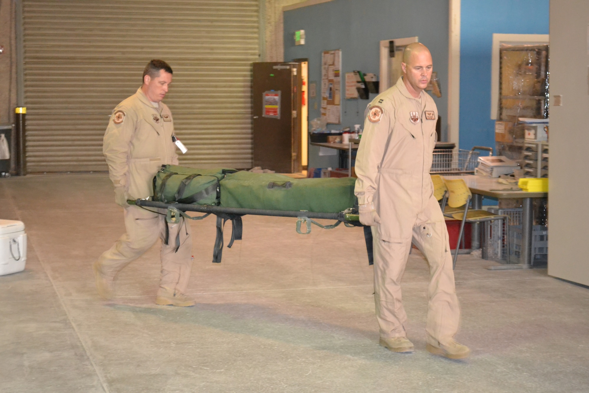 Capt. David Steiner and Technical Sgt. Christopher Caplan, a nurse and medical technician with the 379th Expeditionary Aeromedical Evacuation Squadron, carry an emergency equipment litter in preparation for an AE mission in support of Operation Enduring Freedom, April 16, 2014, Al Udeid Air Base, Qatar.  A crew of two nurses and three medical technicians inspect all emergency equipment litters and medical supplies prior to loading and configuring it on the aircraft to ensure all power operated equipment is running properly and that they have supplies for any and all types of medical emergencies.  Steiner is deployed from the Wyoming Air National Guard and a Fort Collins, Colo. native.  Caplan is a native of Orting, Wash. and deployed from Joint Base Lewis-McChord, Wash.  (U.S. Air Force photo by Maj. Nicole David) 