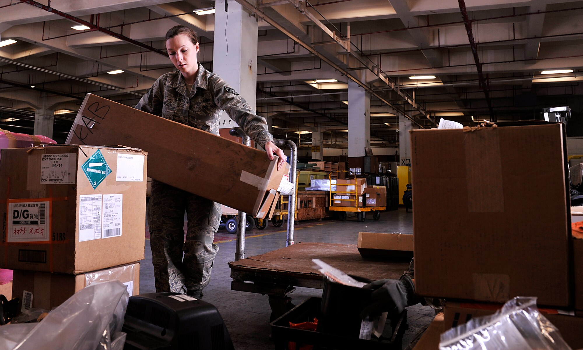 U.S. Air Force Tech. Sgt. Katherine Thurston, 18th Logistic Readiness Squadron flight service center supervisor, moves a box of supplies on Kadena Air Base, Japan, April 15, 2014, that will be sent to the defense reutilization and marketing office at Camp Kinser. The 18th LRS flight service center also receives parts that are unable to be fixed and broken parts of aircraft before being sent off to the U.S. for maintenance or repair.  (U.S. Air Force photo by Naoto Anazawa)