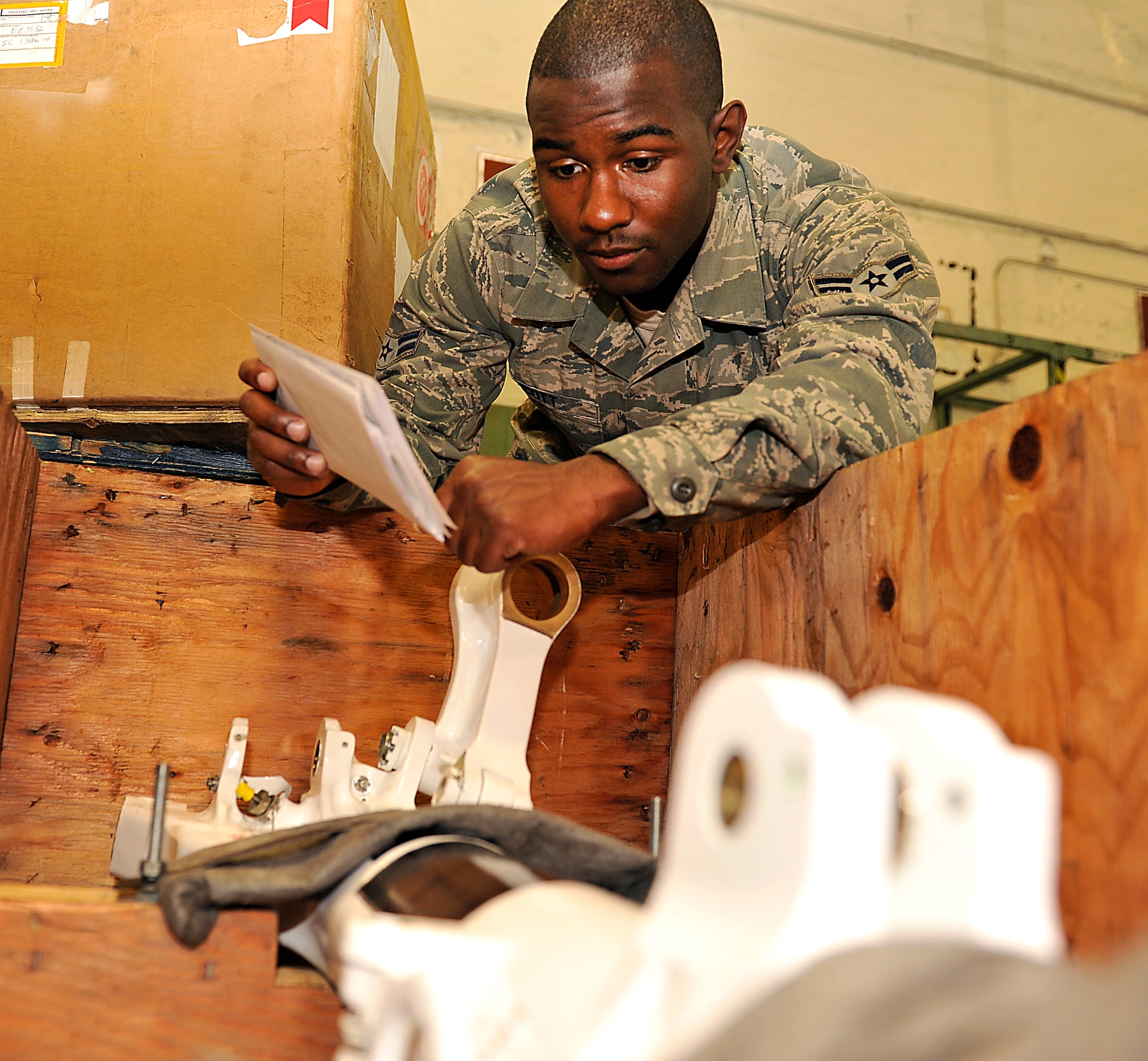U.S. Air Force Airman 1st Class Larry Scott, 18th Logistic Readiness Squadron flight service center journeyman, verifies that a part and its tag numbers match while processing parts on Kadena Air Base, Japan, April 15, 2014. When Airmen are unable to fix parts, the broken parts are routed through the 18th LRS flight service center before being sent back to the U. S. for maintenance or repair. They are also responsible for distributing new and repaired items back to the original units. (U.S. Air Force photo by Naoto Anazawa)