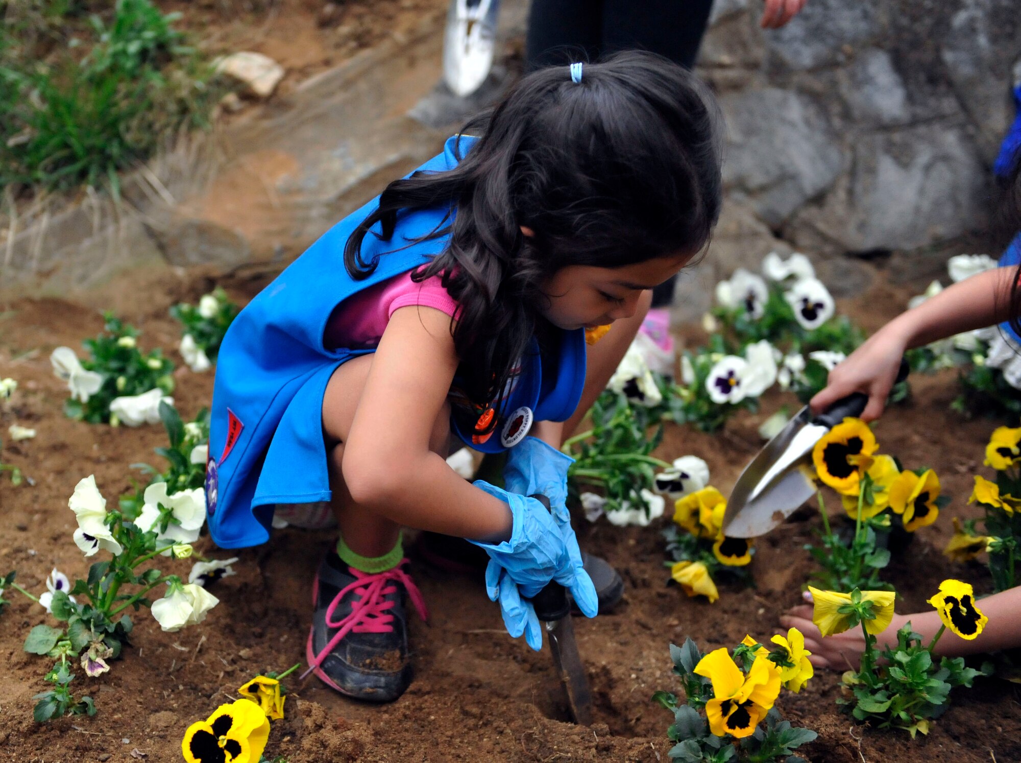 Bea Lyn Villa Garcia, 7, daughter of Master Sgt. Michael Scott, 51st Security Forces Squadron flight chief, digs a hole for a flower during the Arbor Day Tree Planting event April 17, 2014 at Osan Air Base, Republic of Korea. The students planted 10 evergreen trees and 200 flowers. (U.S. Air Force photo by Senior Airman David Owsianka)