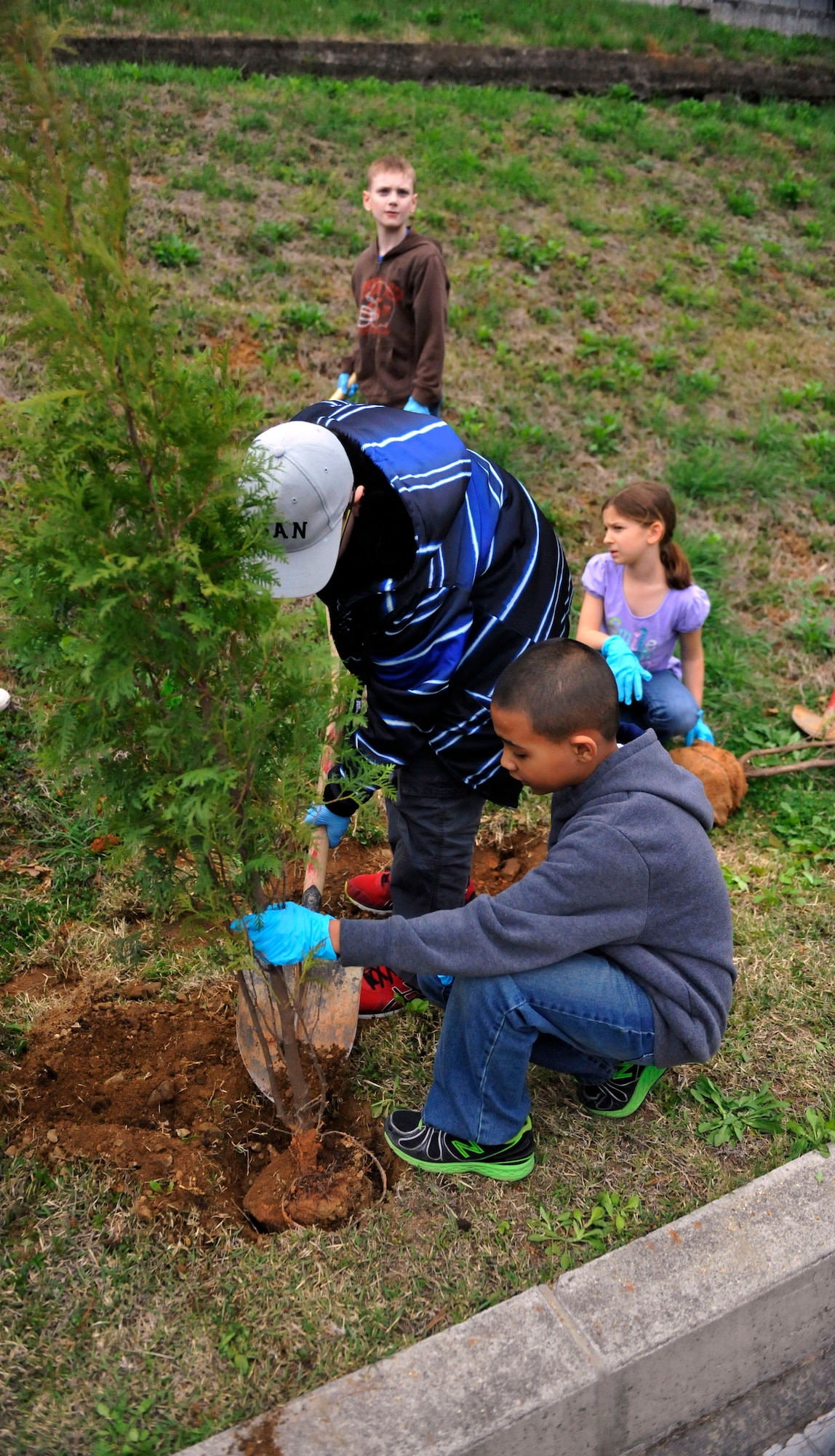 Students from Osan Elementary School plant an evergreen tree during the Arbor Day Tree Planting event April 17, 2014 at Osan Air Base, Republic of Korea. Arbor Day became a public holiday in Korea in 2005 in an effort to restore the forests that had been ravaged by the Korean War. (U.S. Air Force photo by Senior Airman David Owsianka)