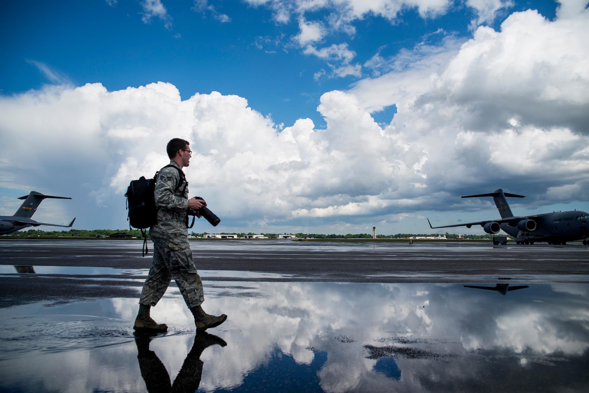 Senior Airman Dennis Sloan walks on the flightline in search of a photo May 5, 2013 at Joint Base Charleston, S.C. A victim of sexual assault, Sloan says his passion for photography keeps him breathing and offers solace from his otherwise painful memories. Sloan is a 628th Air Base Wing Public Affairs photojournalist. (U.S. Air Force photo/ Senior Airman George Goslin) 