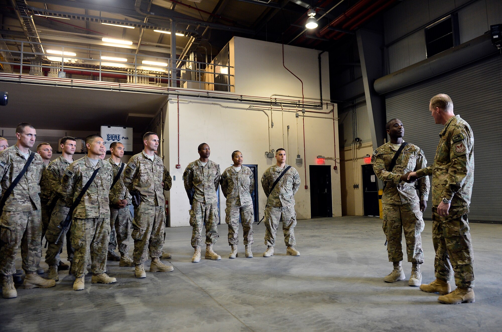 Chief Master Sgt. of the Air Force James A. Cody presents a coin to Senior Airman Courtney Lewis, 455th Expeditionary Logistics Readiness Squadron fuels technician, during his visit to Bagram Air Field, Afghanistan, April 13, 2014. Lewis’ overall attention to detail, on-the-job effort and outstanding Airman skills were recognized by his leadership and Cody. Cody visited Bagram Air Field during his trip through Afghanistan to encourage, inform and thank Airmen for their hard work supporting Operation Enduring Freedom. His visit to Bagram concluded with a 60-minute question and answer all-call with nearly 500 Airmen. (U.S. Air Force photo by Staff Sgt. Vernon Young Jr.)
