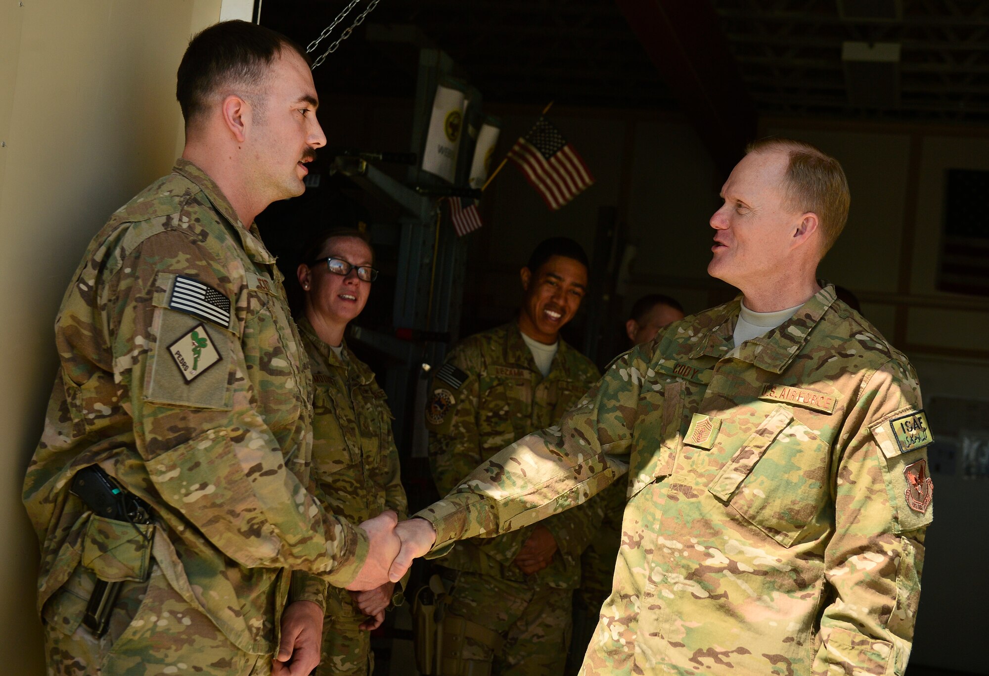 Chief Master Sgt. of the Air Force James A. Cody presents a coin to Staff Sgt. Clint Scott, 83rd Expeditionary Rescue Squadron, aircrew flight craftsman, during a visit to Bagram Air Field, Afghanistan, April 13, 2014. Cody visited Bagram Air Field during his trip through Afghanistan to encourage, inform and thank Airmen for their hard work supporting Operation Enduring Freedom. His visit to Bagram concluded with a 60-minute question and answer all-call with nearly 500 Airmen. (U.S. Air Force photo by Staff Sgt. Vernon Young Jr.)