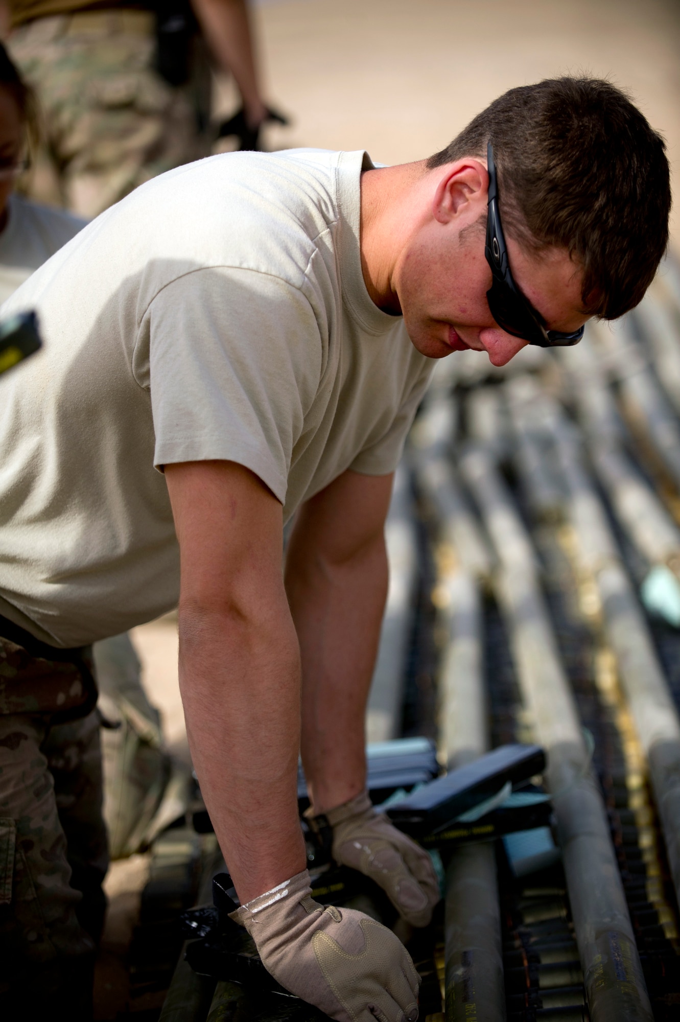 Airman 1st Class Keith Bochert, an explosive ordnance disposal technician from Patrick Air Force Base, Fla., carefully arranges munitions slated for disposal at an undisclosed location in Southwest Asia.  Bochert is deployed to the 386th Expeditionary Civil Engineer Squadron. (U.S. Air Force photo by Senior Master Sgt. Burke Baker)(This image was manipulated for security purposes)    