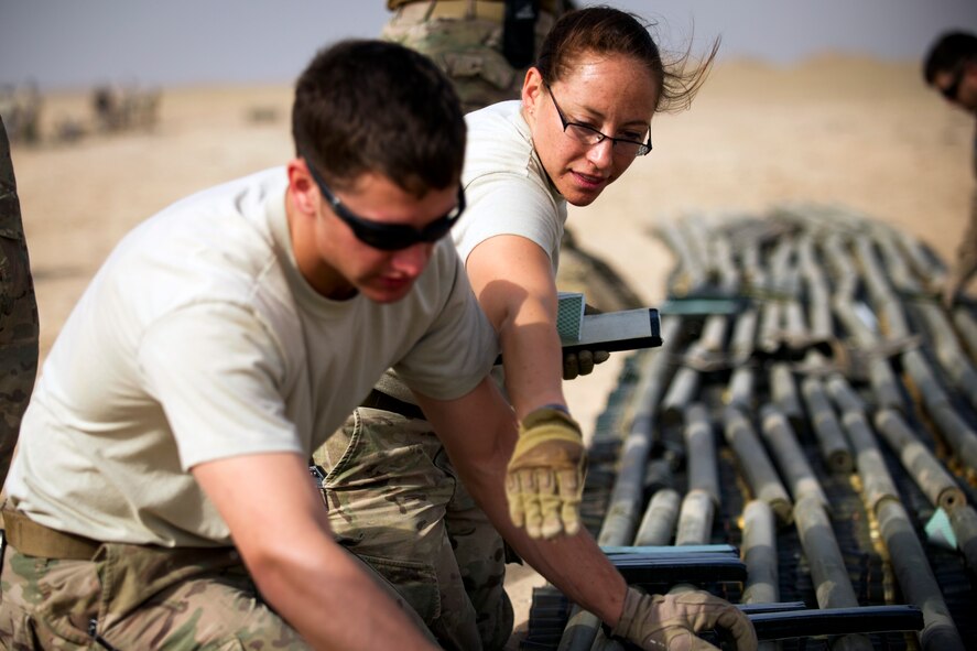 Tech. Sgt. Angela Olguin, an explosive ordnance disposal technician, instructs Airman 1st Class Keith Bochert on properly placing explosive charges on munitions slated for disposal at an undisclosed location in Southwest Asia.  The two EOD Airmen have been deployed to the 386th Expeditionary Civil Engineer Squadron since mid-January. (U.S. Air Force photo by Senior Master Sgt. Burke Baker)