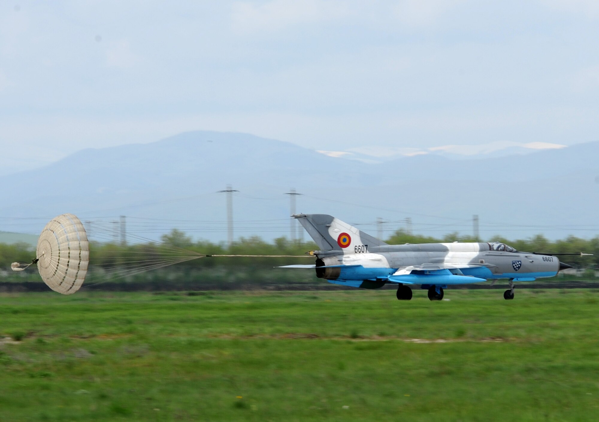 A Romanian air force MiG-21 Lancer deploys a parachute to slow its speed upon landing at Campia Turzii, Romania, April 17, 2014. The parachute acts as an additional breaking system for the aircraft. (U.S. Air Force photo/Staff Sgt. R.J. Biermann)