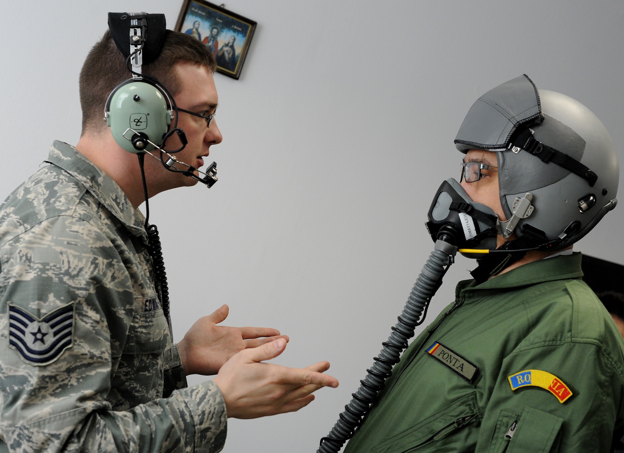 Tech. Sgt. Ryan Edwards, 510th Fighter Squadron life support NCO in charge fits Romanian Prime Minister Victor Ponta with a helmet and mask before his incentive ride in an F-16 Fighting Falcon. Ponta co-piloted the F-16 with Maj. Dustin Brown, 510th FS F-16 pilot. (U.S. Air Force photo/Staff Sgt. R.J. Biermann)