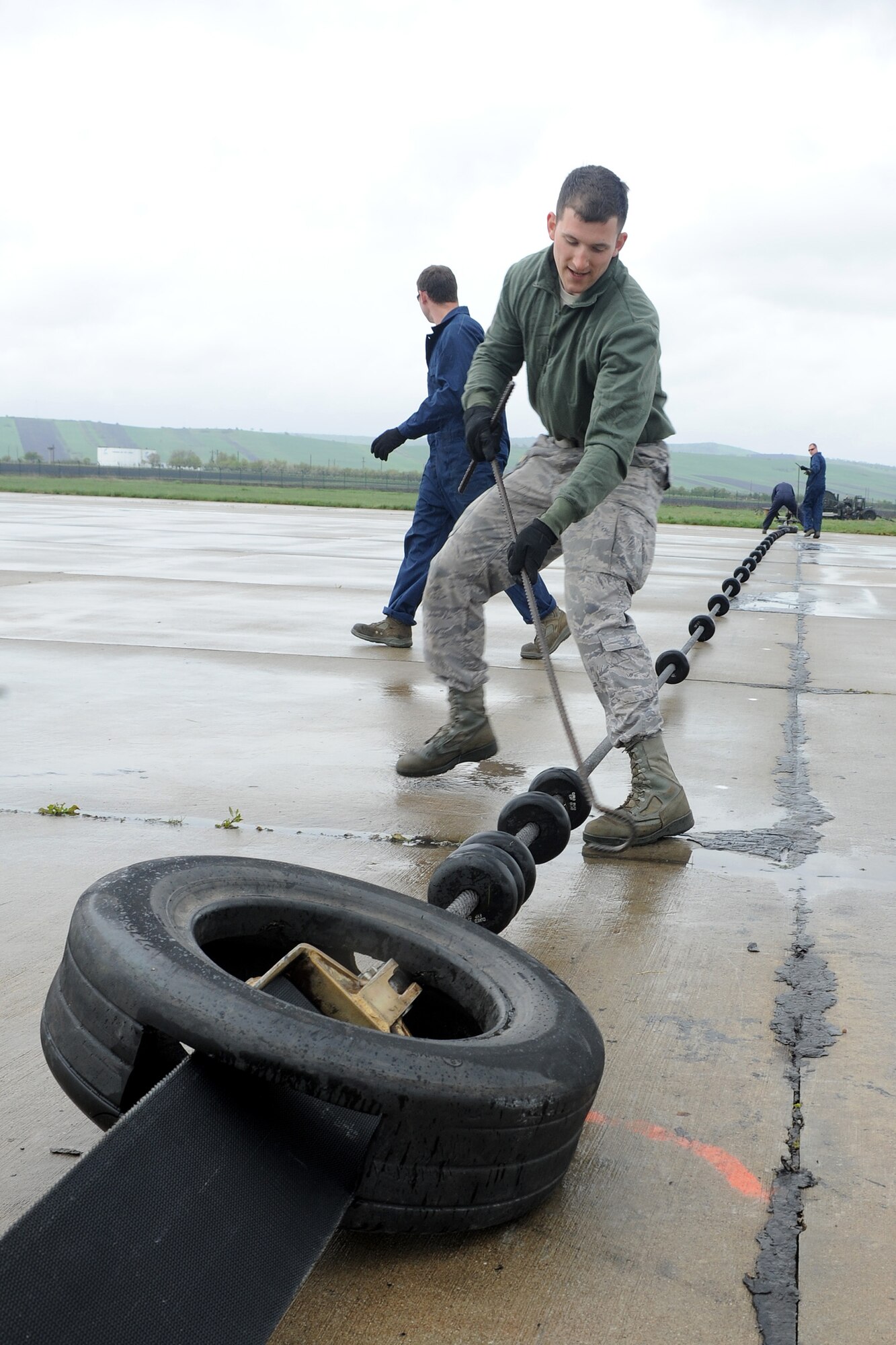 Staff Sgt. Jared Carlisle, 435th Construction and Training Squadron aircraft arresting system technician, spaces out small wheels on an arresting system cable at Campia Turzii, Romania, April 16, 2014. The system catches an aircraft’s tail hook when its brake system is inoperable. (U.S. Air Force photo/Staff Sgt. R.J. Biermann)