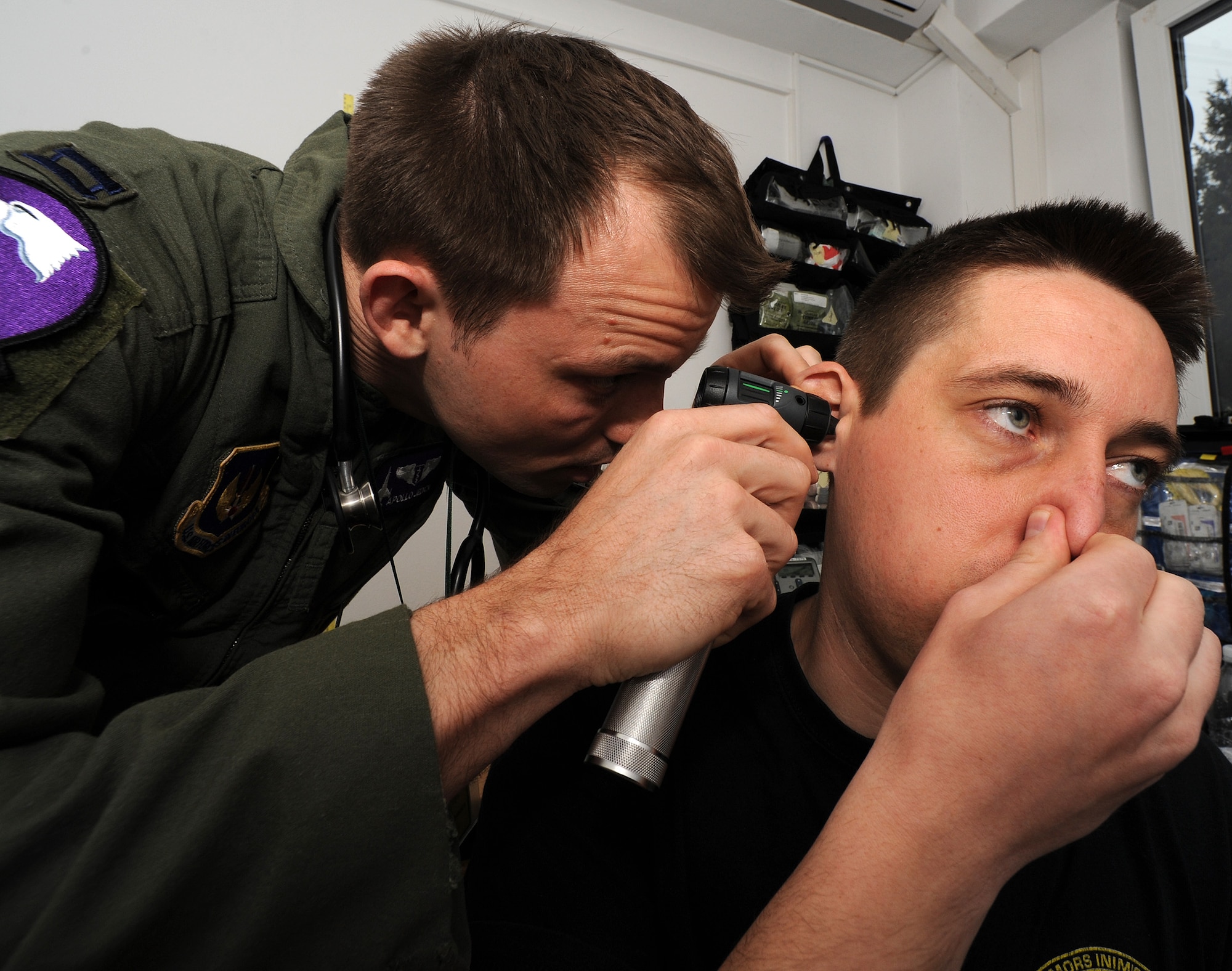 Capt. (Dr.) Rocky Jedick, 510th Fighter Squadron flight surgeon, checks the ears of Capt. Gabriel Andrnsear, 711th Squadron MiG-21 Lancer pilot, as he clears his ears before an F-16 Fighting Falcon incentive ride at Campia Turzii, Romania, April 15, 2014. Individuals who receive F-16 incentive rides must pass a simple physical. (U.S. Air Force photo/Staff Sgt. R.J. Biermann) 