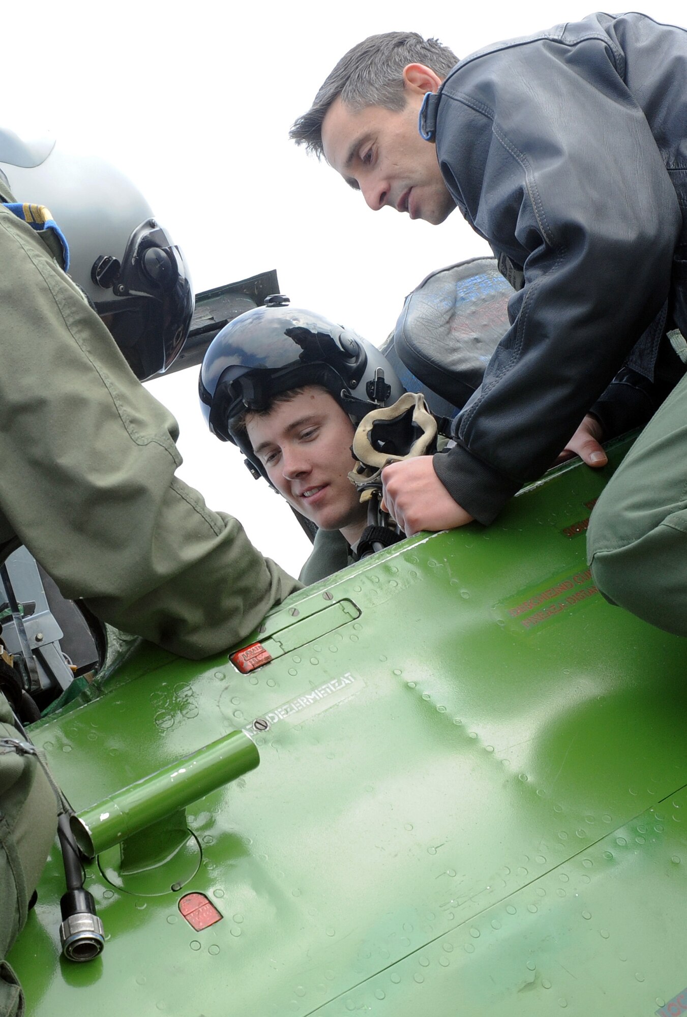 Romanian air force Lt. Col. Marius Iova, 711th Squadron MiG-21 Lancer pilot, right, familiarizes Capt. Justin Bellamy, 510th Fighter Squadron F-16 Fighting Falcon pilot, with the MiG-21 Lancer cockpit at Campia Turzii, Romania, April 14, 2014. Various American pilots had the opportunity to fly in the MiG-21 during Dacian Viper 2014, an interoperability exercise involving American and Romanian militaries. (U.S. Air Force photo/Staff Sgt. R.J. Biermann)