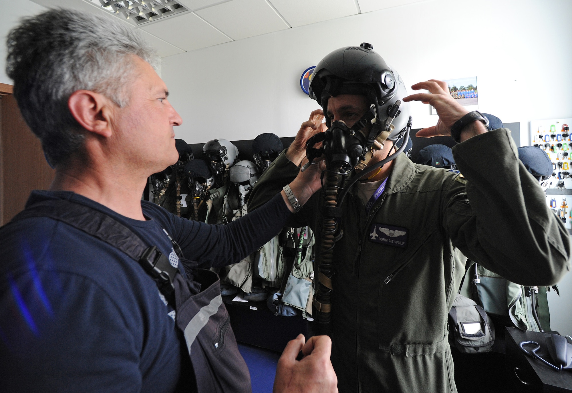 Donica Petrica, 711th Squadron maintainer, fits Capt. Nicolas DeWulf, 510th Fighter Squadron F-16 Fighting Falcon pilot, in a helmet at Campia Turzii, Romania, April 14, 2014. The exercise, which began April 10, enhanced interoperability and readiness between the NATO partners through combined air operations between F-16 Fighting Falcons from Aviano Air Base, Italy, and MiG-21 Lancers from the 71st Air Base. (U.S. Air Force photo/Staff Sgt. R.J. Biermann)