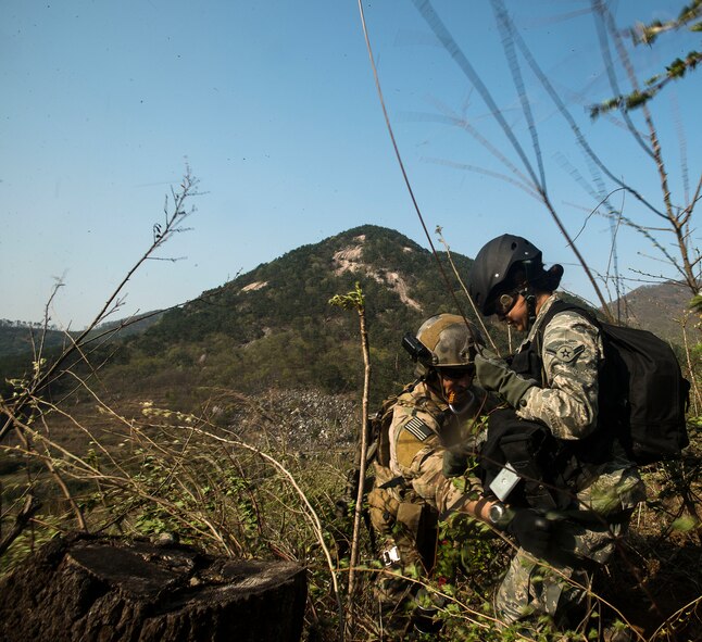 Airman Danielle Trejo, a simulated injury victim, is helped into a lift-belt by a Survival, Evasion, Resistance and Escape specialist during exercise Pacific Thunder April 14, 2014, in the Republic of Korea. The exercise is designed to test the United States and RoK's abilities in numerous contingency situations, including search and rescue missions. (U.S. Air Force photo by Staff Sgt. Jake Barreiro)