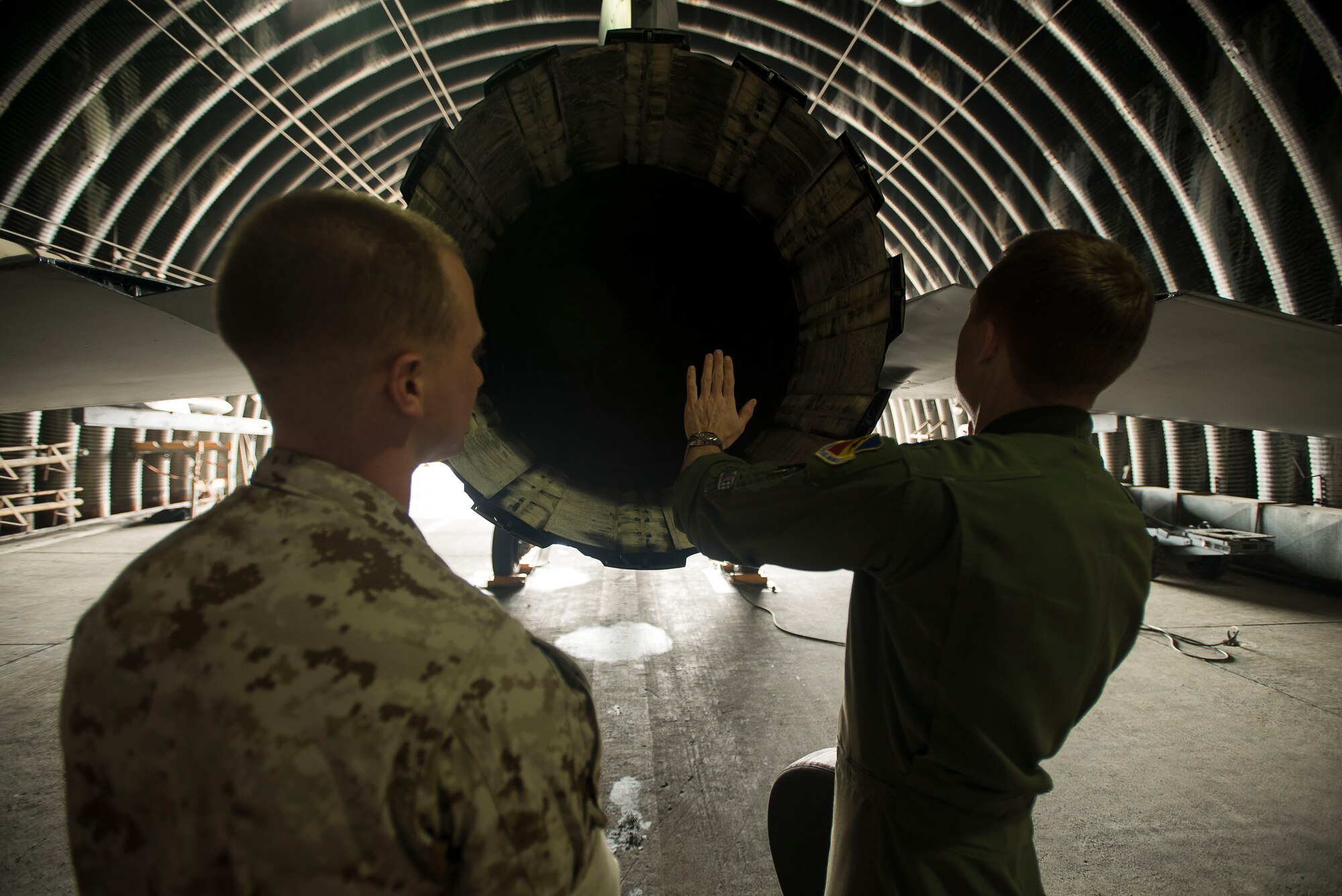 Cpl. Jake Balcom is shown the exhaust end of an F-16 Fighting Falcon by Capt. Jay Doerfler March 26, 2014, at Osan Air Base, Republic of Korea. Balcom spent two days touring his grandfather's old squadron, the 421st Fighter Squadron, which was deployed to Osan AB from Hill Air Force Base, Utah. Doerfler is the 421st Fighter Squadron chief of training. (U.S. Air Force photo/Staff Sgt. Jake Barreiro)