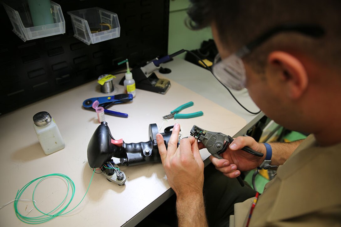 Cpl. Brandon Kelsey, an aviation electronic microminiature instrument and cable repair technician  with Marine Aviation Logistics Squadron 31, replaces wires in a left-handed grip assembly inside a mobile maintenance facility, April 4.  Mobile maintenance facilities are set up for each specific work center and easily transported.