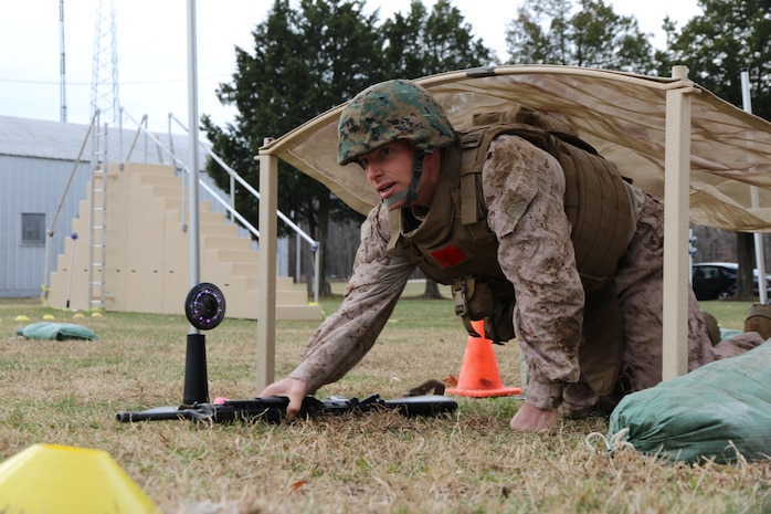 2nd Lt. Andrew Petrevics, a student at The Basic School, passes by the fitLight Trainer sensor after completing the high-crawl obstacle on Marine Corps Systems Command’s Marine Corps Load Effects Assessment Program, or MCLEAP, course Dec. 20, 2013, on Marine Corps Base Quantico, Va. Petrevics was part of a group of Marines testing the fitLight timing system, an upgrade MCSC’s Marine Expeditionary Rifle Squad team made to MCLEAP to obtain more concise data for improving current and future gear for infantry Marines. 
