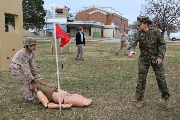 Capt. Caelyn Furman (left), project officer for Marine Corps Systems Command’s Marine Expeditionary Rifle Squad team, coaches 2nd Lt. Ana DelValle through the casualty drag obstacle on MCSC’s Marine Corps Load Effects Assessment Program, or MCLEAP, course Dec. 20, 2013, on Marine Corps Base Quantico, Va. DelValle was one of a group of Marines testing the fitLight timing system, an upgrade the MERS team made to MCLEAP to obtain more concise data for improving current and future gear for infantry Marines. 