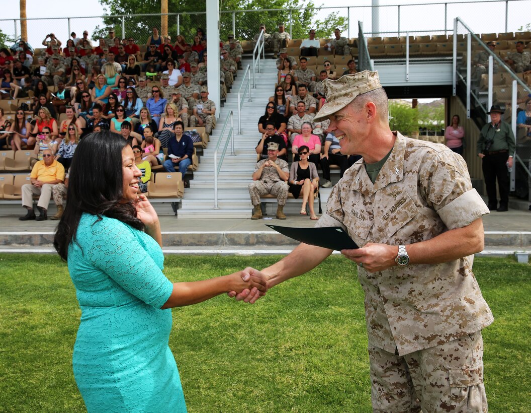 Tina Martinez, volunteer, 3rd Battalion, 7th Marine Regiment, shakes hands with Col. James B. Hanlon, Combat Center chief of staff, while receiving an award during the second Installation Volunteer Appreciation Ceremony at Lance Cpl. Torrey L. Gray Field, April 9, 2014. "Although we are only recognizing the volunteers for roughly an hour during this ceremony, their contributions deserve constant and continuous recognition," Hanlon said. (Official Marine Corps Photo By Lance Cpl. Kasey Peacock/Released)