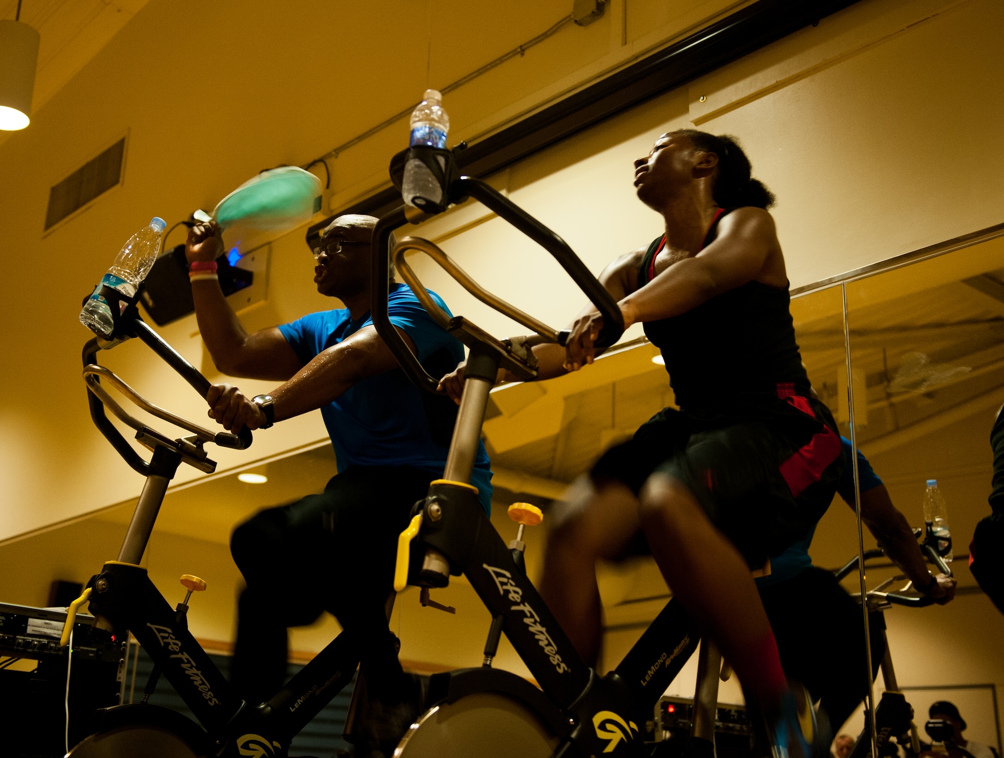 Master Sgt. Dante Brooks, 8th Operations Support Squadron host aviation resource management superintendent, and Staff Sgt. Siera Wilson, 8th Operations Group, lead a spin class at Kunsan Air Base, Republic of Korea, April 16, 2014. Spin class is offered four times a week at the Wolf Pack Fitness Center. (U.S. Air Force photo by Staff Sgt. Clayton Lenhardt/Released)