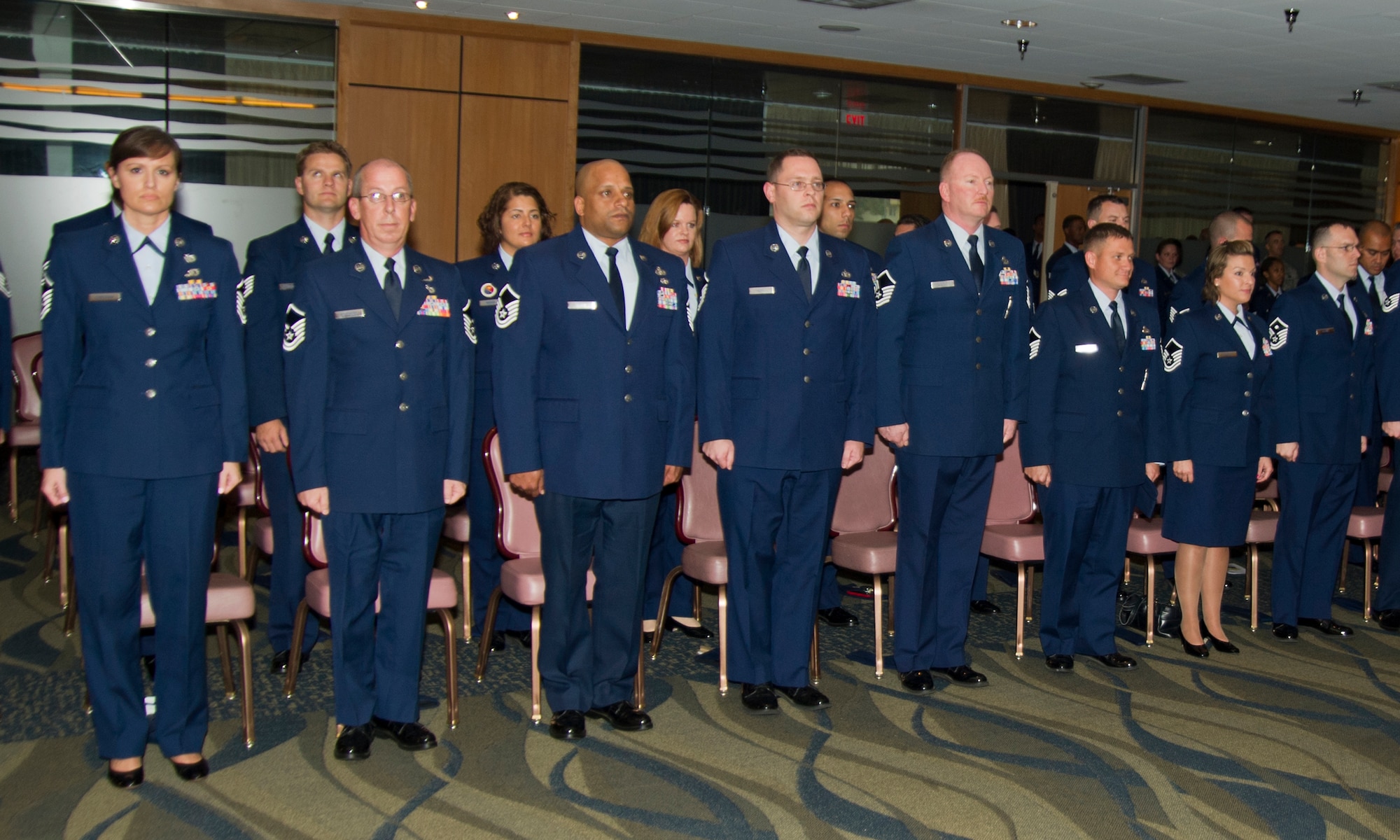 Airmen file in and stand at attention during the Community College of the Air Force graduation ceremony held at Horizons, April, 18. Though 166 graduates were honored, not all were able to attend due to deployments, permanent changes of station, retirements or separations. (U.S. Air Force photo by Airman 1st Class Alex Echols)
