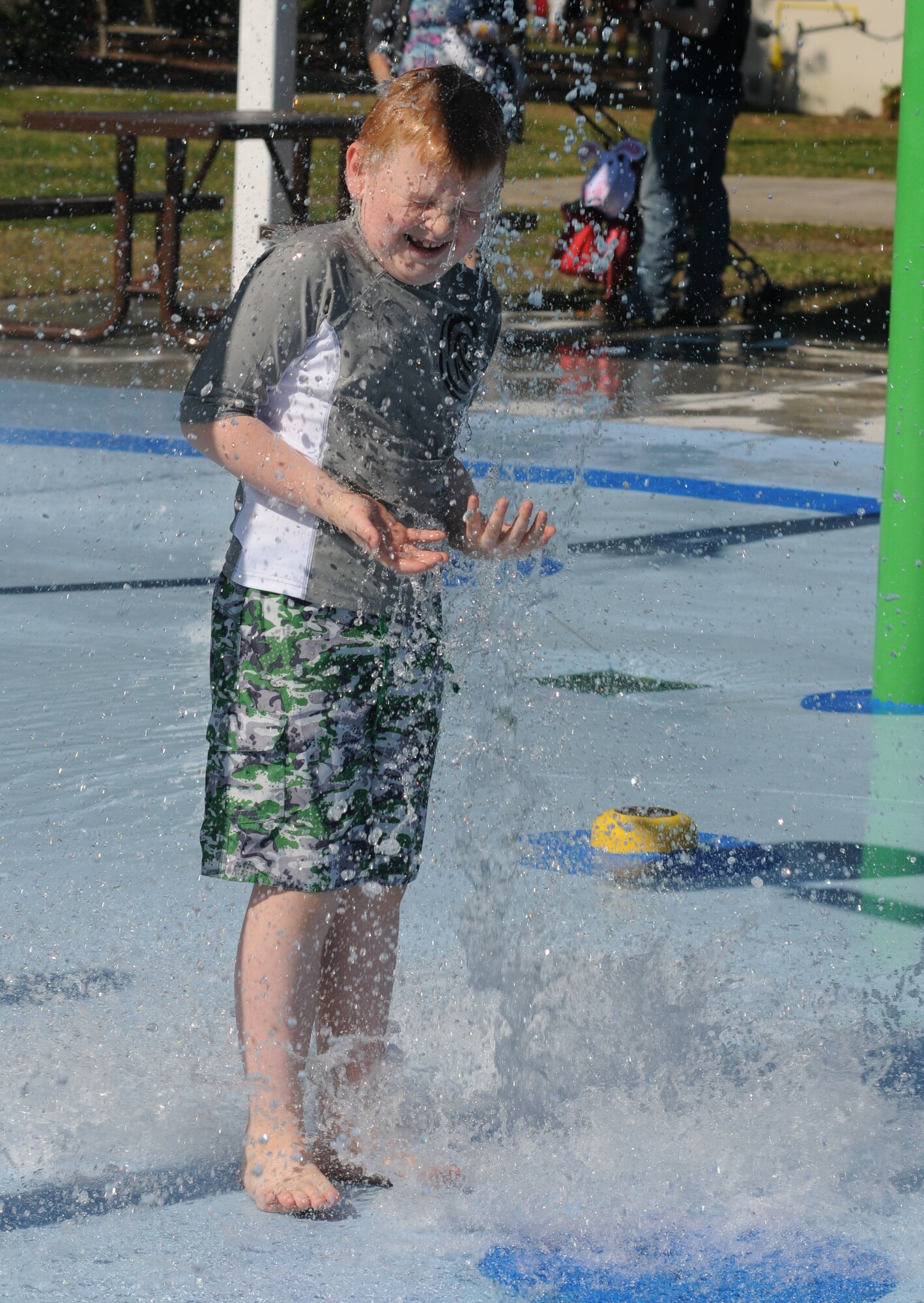 The son of Brig. Gen. Patrick Higby, 81st Training wing commander, laughs as a bucket of water is dumped on him during the Keesler Outdoor Recreation’s Splash Pad grand opening at the marina April 19, 2014, at Keesler Air Force Base, Miss.  The splash pad was funded with a portion of the 2013 Commander-in-Chief Installation Excellence award funds.  (U.S. Air Force photo by Kemberly Groue)