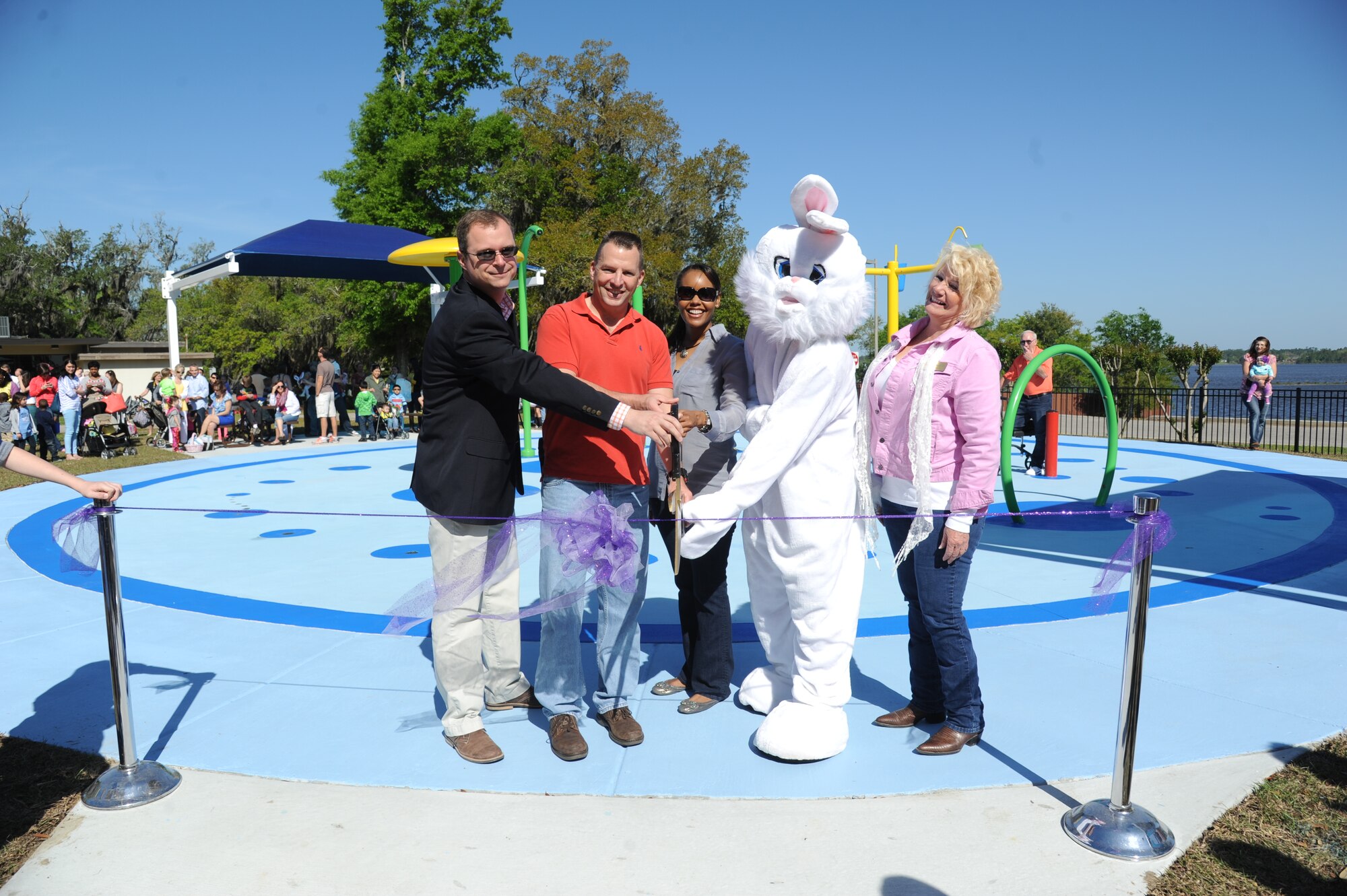 Andy Marasca, Engineering Services supervisor and splash pad project manager; Brig. Gen. Patrick Higby, 81st Training wing commander; Lt. Col. Sharon Nickelberry, 81st Force Support Squadron commander; The Easter Bunny and Barbara Medlock, 81st FSS, prepare to cut the ribbon during the Keesler Outdoor Recreation’s Splash Pad grand opening at the marina April 19, 2014, at Keesler Air Force Base, Miss.  The splash pad was funded with a portion of the 2013 Commander-in-Chief Installation Excellence award funds.  (U.S. Air Force photo by Kemberly Groue)