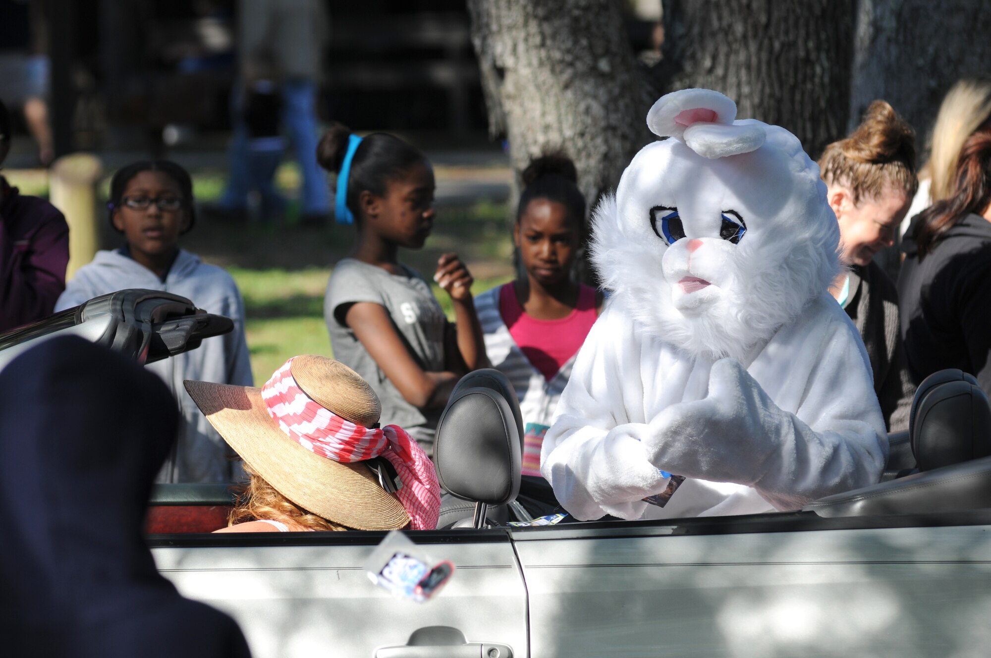 The Easter Bunny tosses toys to Keesler children as he participates in an Easter parade April 19, 2014, at the marina, Keesler Air Force Base, Miss.  The parade was followed by an Easter egg hunt and the grand opening of the outdoor Recreation’s splash pad.  (U.S. Air Force photo by Kemberly Groue)