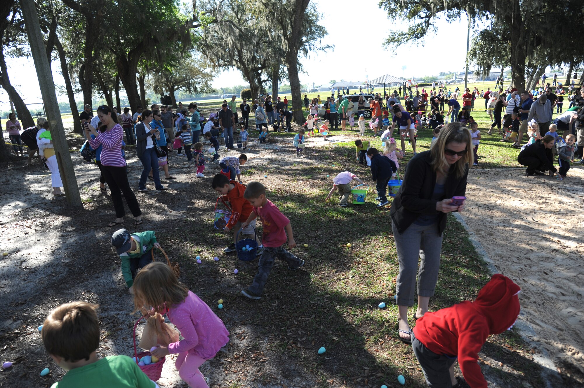 Keesler parents watch as their children scramble for plastic eggs during an Easter egg hunt April 19, 2014, at the marina, Keesler Air Force Base, Miss.  A parade through the marina preceded the hunt then the grand opening of the outdoor recreation’s splash pad immediately completed the festivities.  (U.S. Air Force photo by Kemberly Groue)