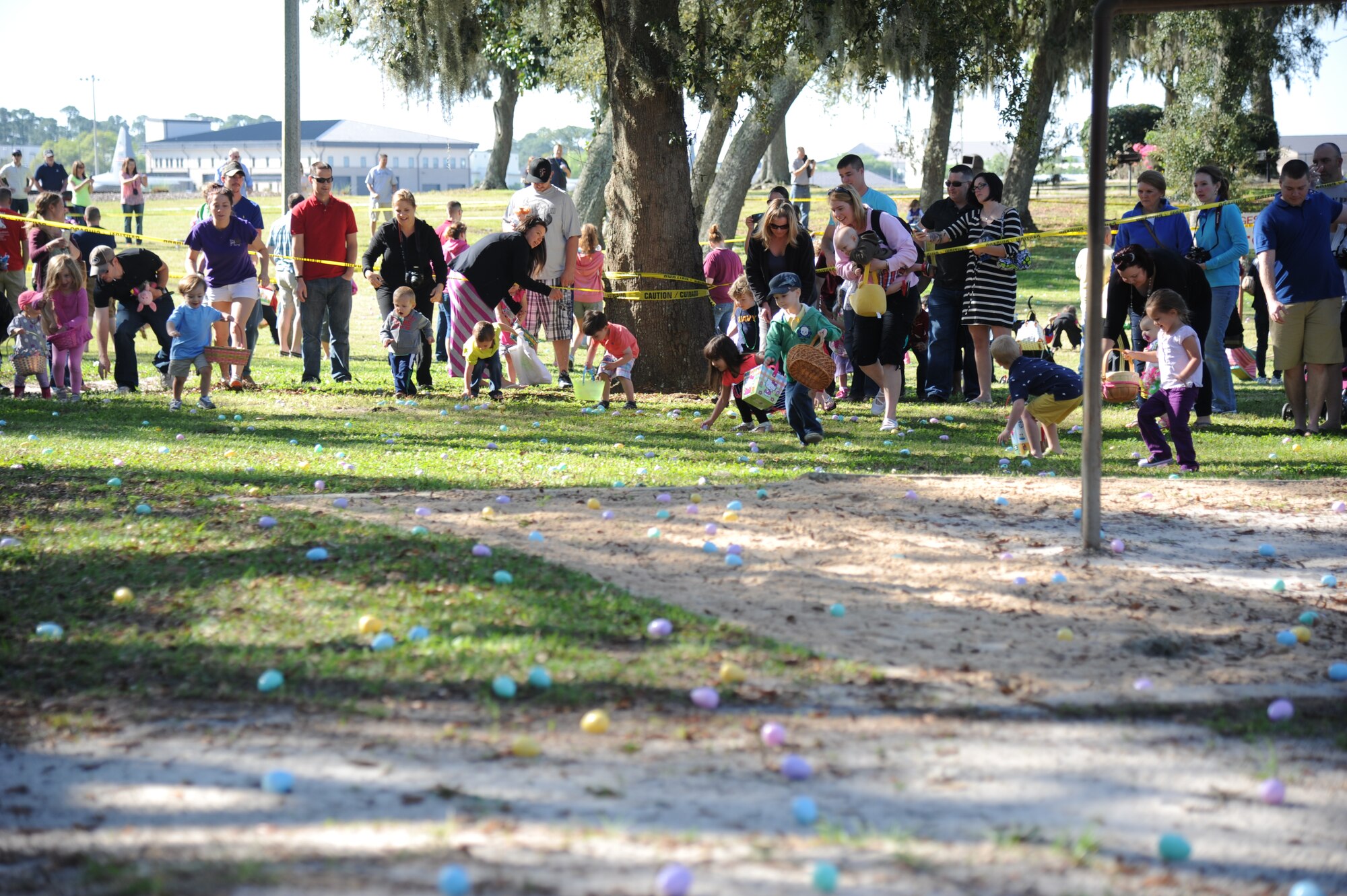 Keesler parents watch as their children scramble for plastic eggs during an Easter egg hunt April 19, 2014, at the marina, Keesler Air Force Base, Miss.  A parade through the marina preceded the hunt then the grand opening of the outdoor recreation’s splash pad immediately completed the festivities.  (U.S. Air Force photo by Kemberly Groue)