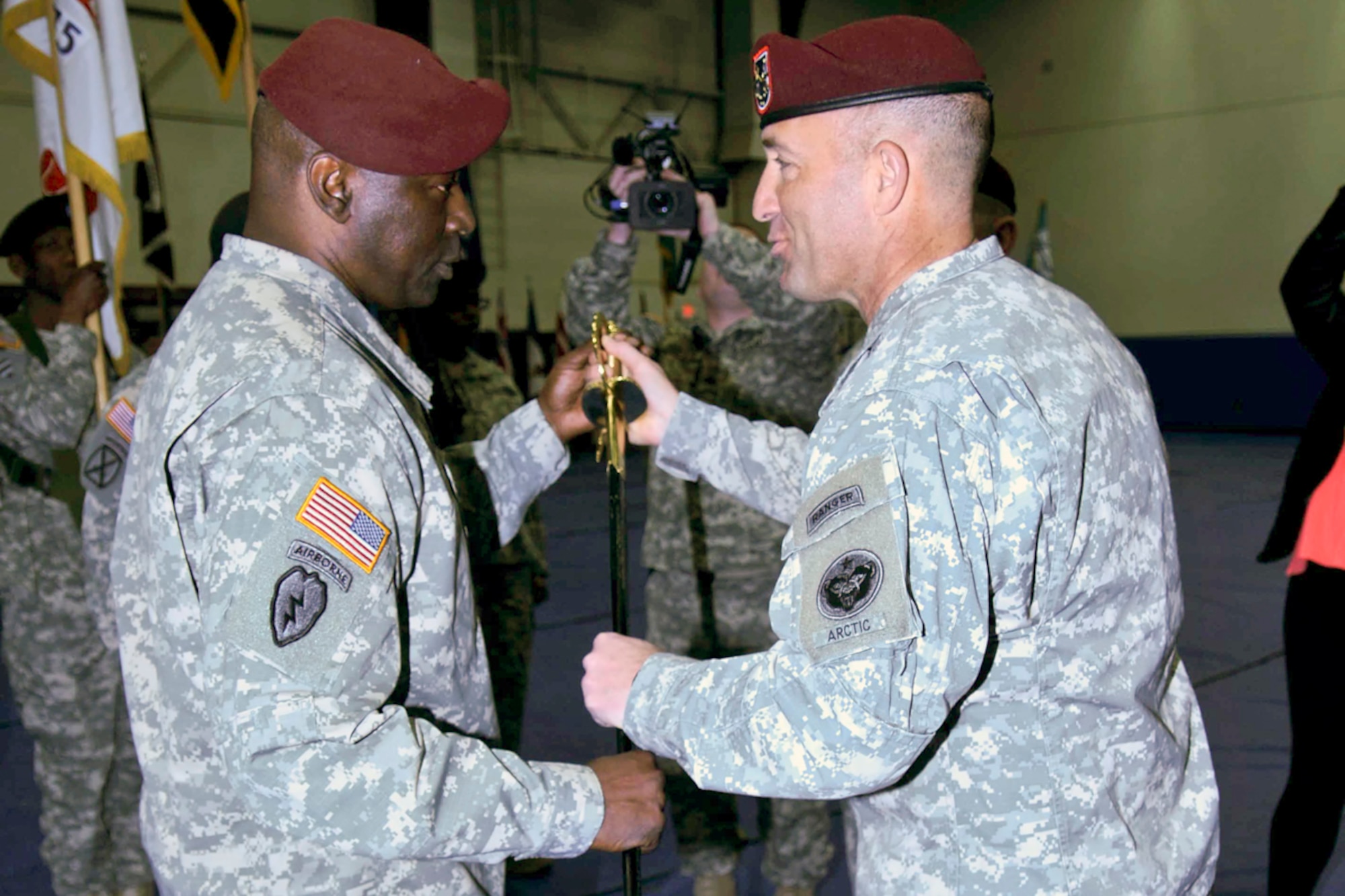 Army Maj. Gen. Michael Shields (right), U.S. Army Alaska commanding general, passes the sword to Command Sgt. Maj. Terry Gardner, symbolizing delegation of authority and entrusting Gardner with the responsibility and care of the unit during the USARAK change of responsibility ceremony April 11 at Buckner Physical Fitness Center. (U.S. Army photo/Master Sgt. Jennifer K. Yancey)