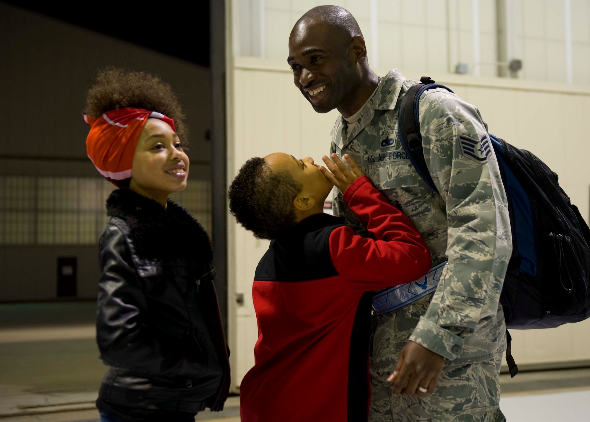 U.S. Air Force Staff Sgt. Ashley Freeman, 1st Maintenance Squadron low observable technician, is hugged by his son Ashley Freeman Jr. and daughter Aneesa Freeman at Langley Air Force Base, Va., April 19, 2014. The 94th Fighter Squadron was deployed for nearly four-months to Kadena Air Base, Japan, to demonstrate the continued U.S. commitment to help maintain peace throughout the Western Pacific. (U.S. Air Force photo by Staff Sgt. John D. Strong II/Released)