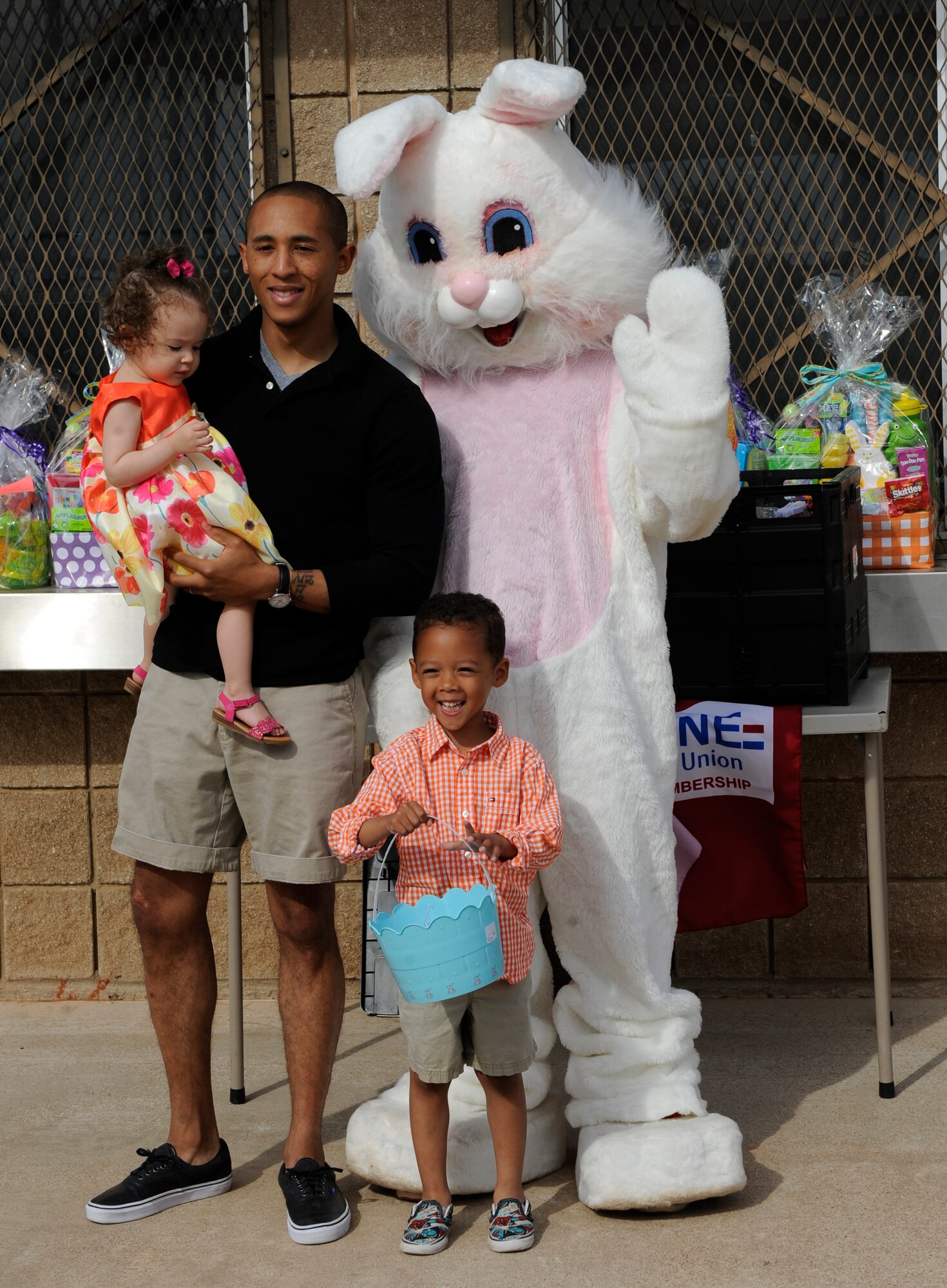U.S. Air Force Staff Sgt. Keaston Simmons, 7th Contracting Squadron, and his children say hello to the Easter bunny April 12, 2014, at Dyess Air Force Base, Texas. The annual Easter egg hunt was held at the Youth Center baseball fields and was offered to children of different age groups throughout the morning. (U.S. Air Force photo by Airman 1st Class Alexander Guerrero/Released)