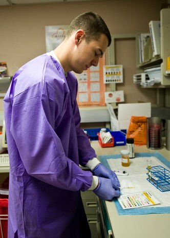 Senior Airman Timothy Eikom, 99th Medical Support Squadron medical laboratory technician, uses a reagent strip for urinalysis April 14, 2014, at Nellis Air Force Base, Nev. Test results can be used along with other diagnostic information to rule out certain disease states and to determine if microscopic analysis is needed. (U.S. Air Force photo by Senior Airman Jason Couillard)