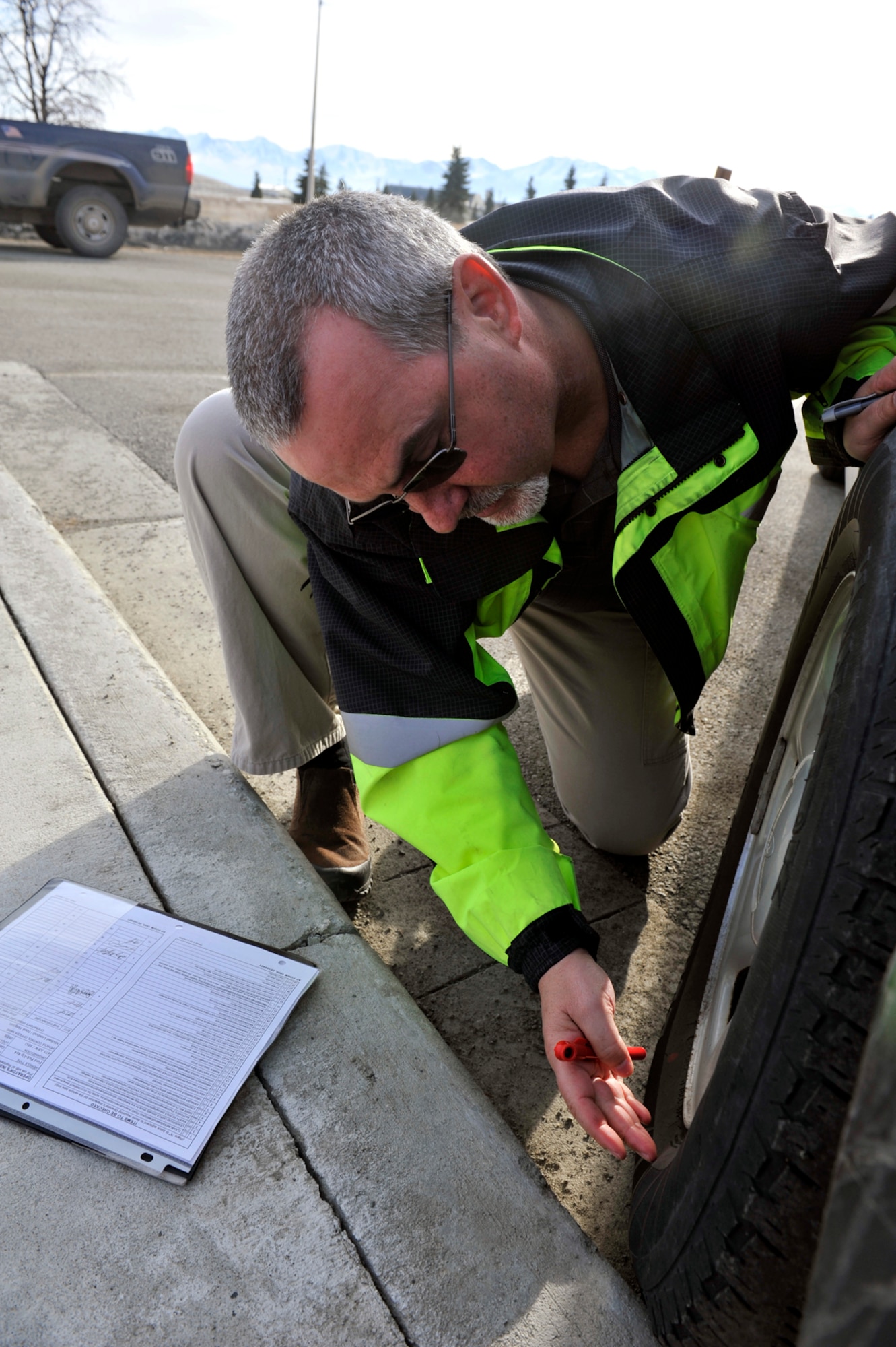 Michael Lundvall, 673d Air Base Wing Safety ground safety lead and vehicle control officer, checks the pressure per square inch in the tire of a government vehicle on Joint Base Elmendorf-Richardson, Alaska, April 16, 2014. Lundvall is one of more than 160 VCOs on JBER who conduct monthly government vehicle inspections. (U.S. Air Force photo/Airman 1st Class Tammie Ramsouer)