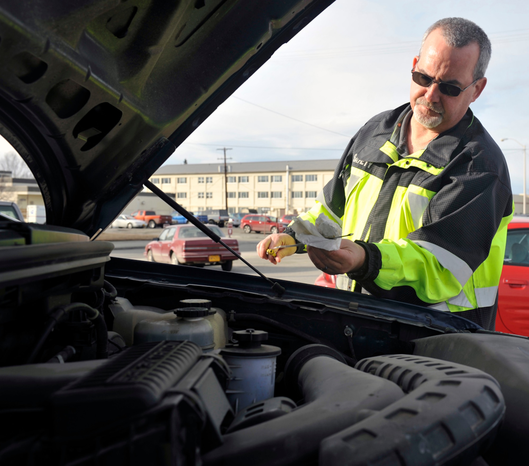 Michael Lundvall, 673d Air Base Wing Safety ground safety lead and vehicle control officer, checks the oil level of a government vehicle on Joint Base Elmendorf-Richardson, Alaska, April 16, 2014. The vehicle control officer program is a liaison between the 673d Logistics Readiness Squadron vehicle management analysis and units using government owned vehicles. (U.S. Air Force photo/Airman 1st Class Tammie Ramsouer)