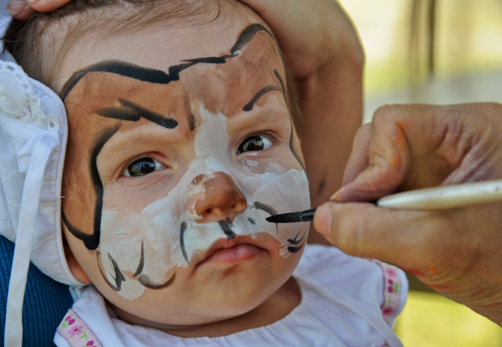 Sabrina Sondriel, 7 months, daughter of retired Tech. Sgt. Marc Sondriel, gets her face painted April 12 during the annual Luke Air Force Base Spring Fest event at Fowler Park. (U.S. Air Force photo/Staff Sgt. Darlene Seltmann)